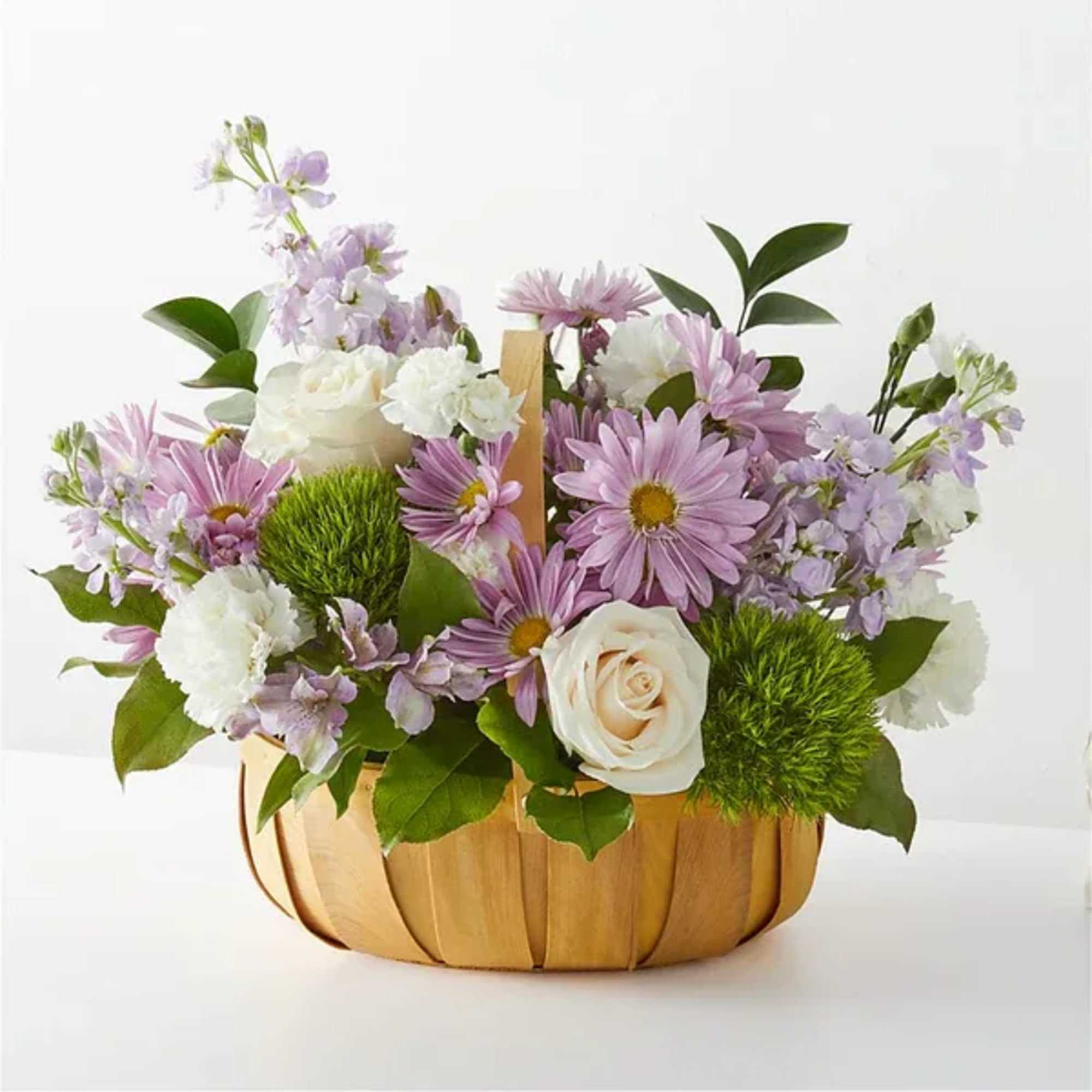Basket arrangement of lavender and white flowers with green accents