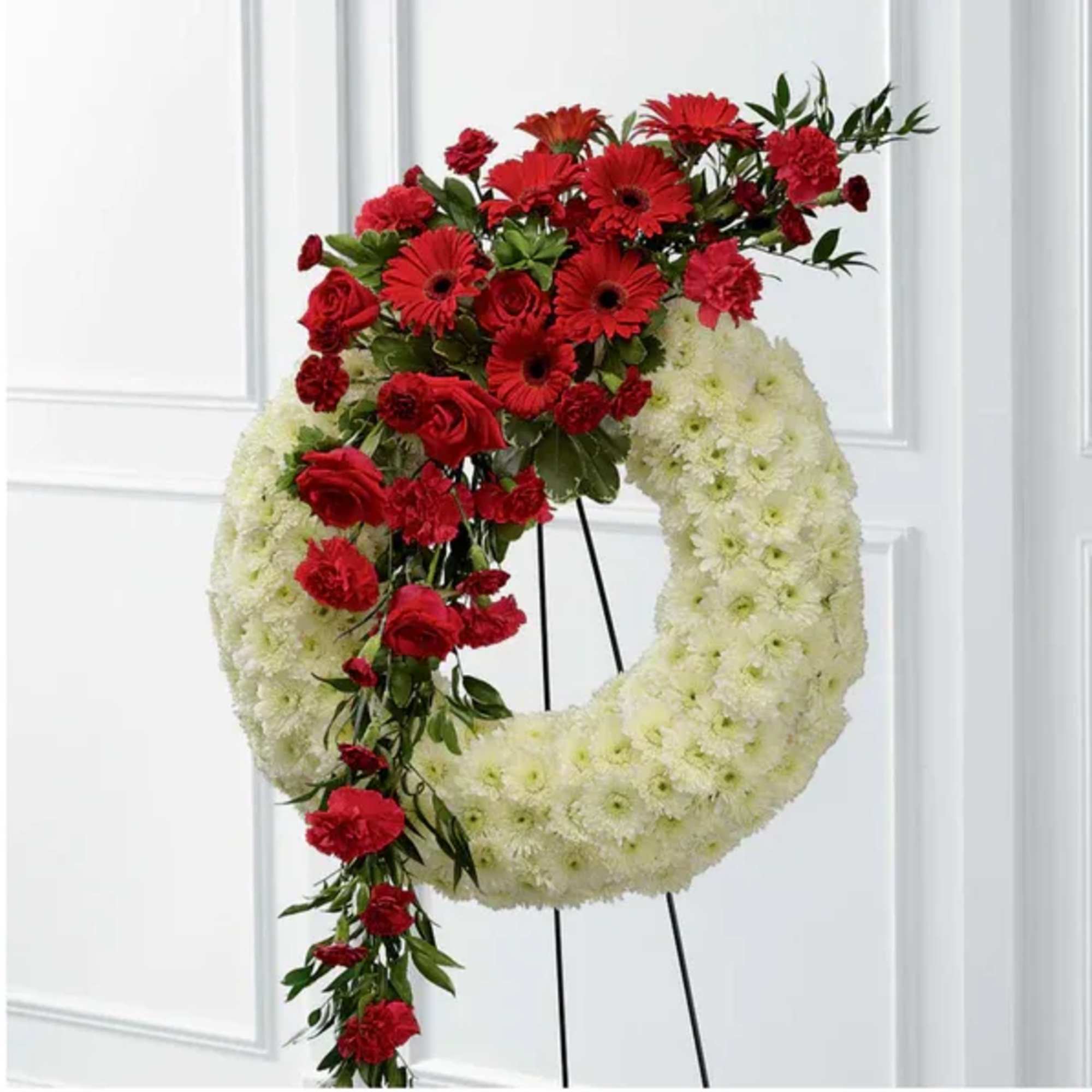 Red and white floral wreath on a stand