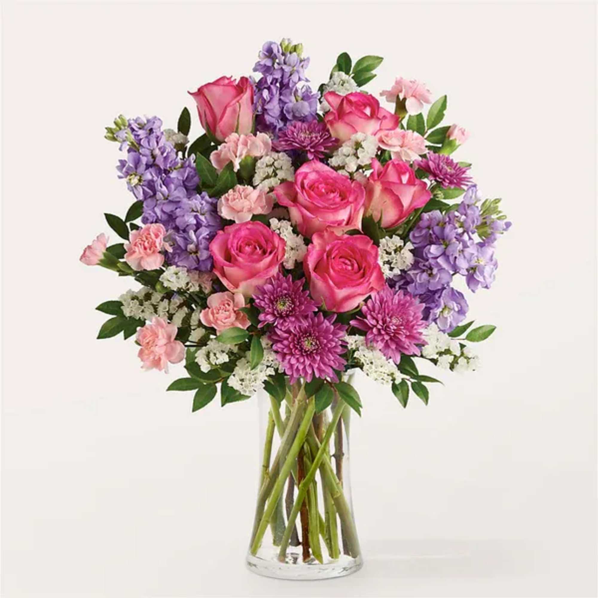 Pink roses and purple flowers in a clear glass vase