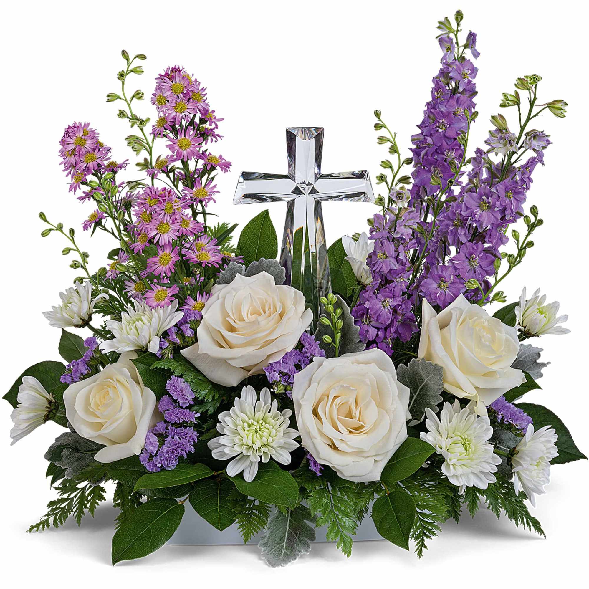 White roses and purple flowers arranged around a clear glass cross