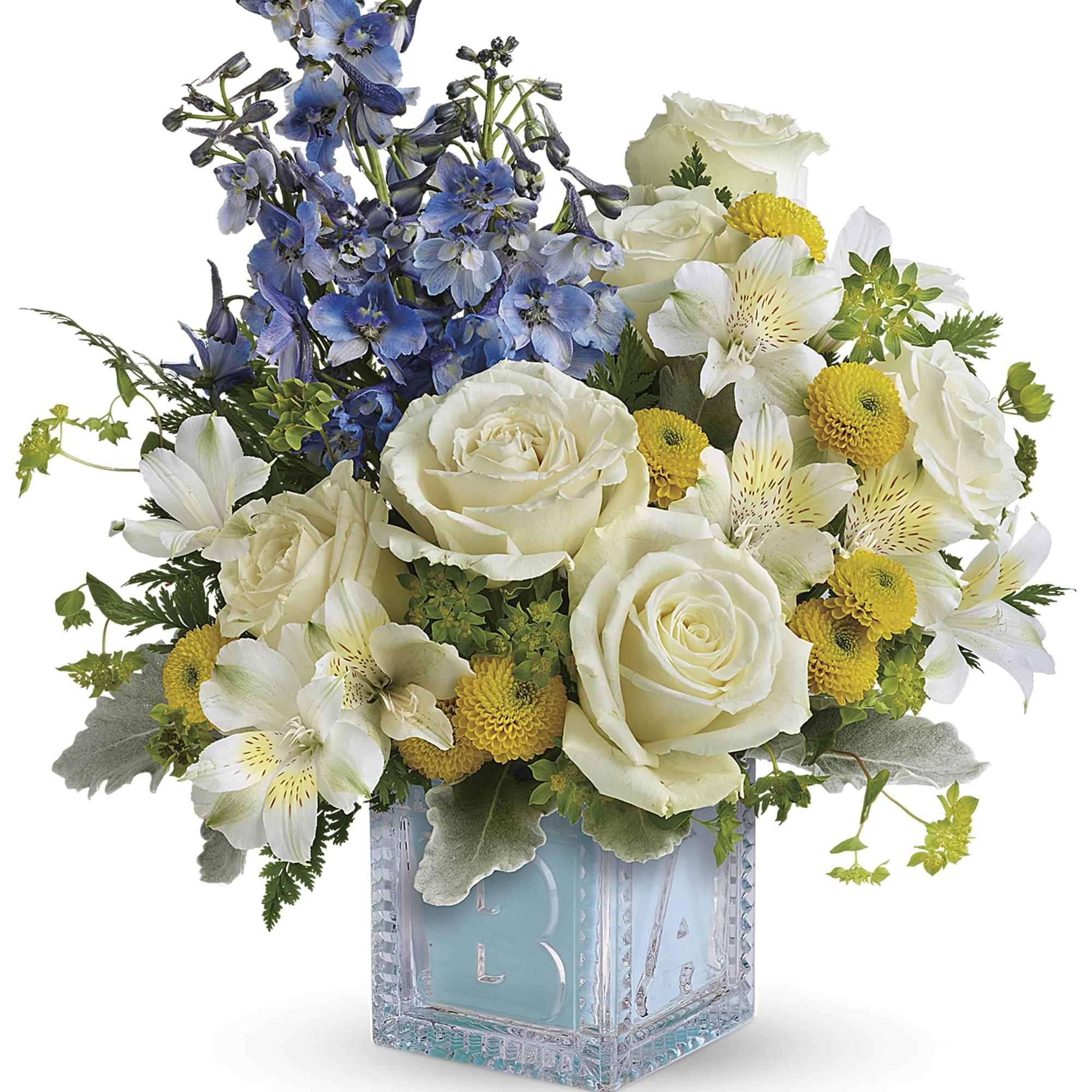 White roses, blue delphinium, and yellow blooms in a glass vase