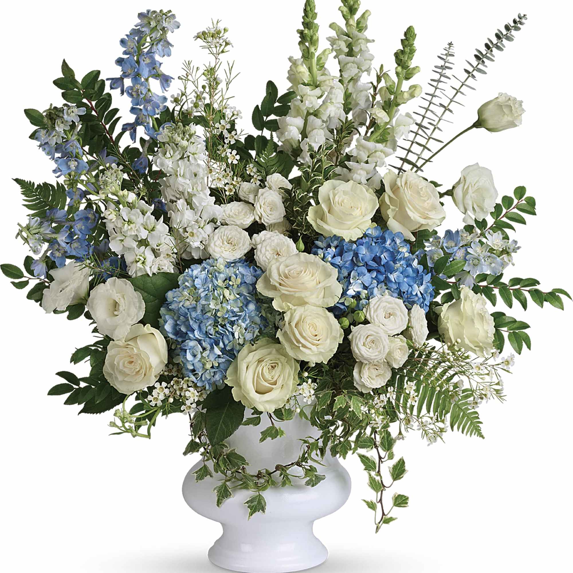 White and blue floral arrangement in a white urn vase