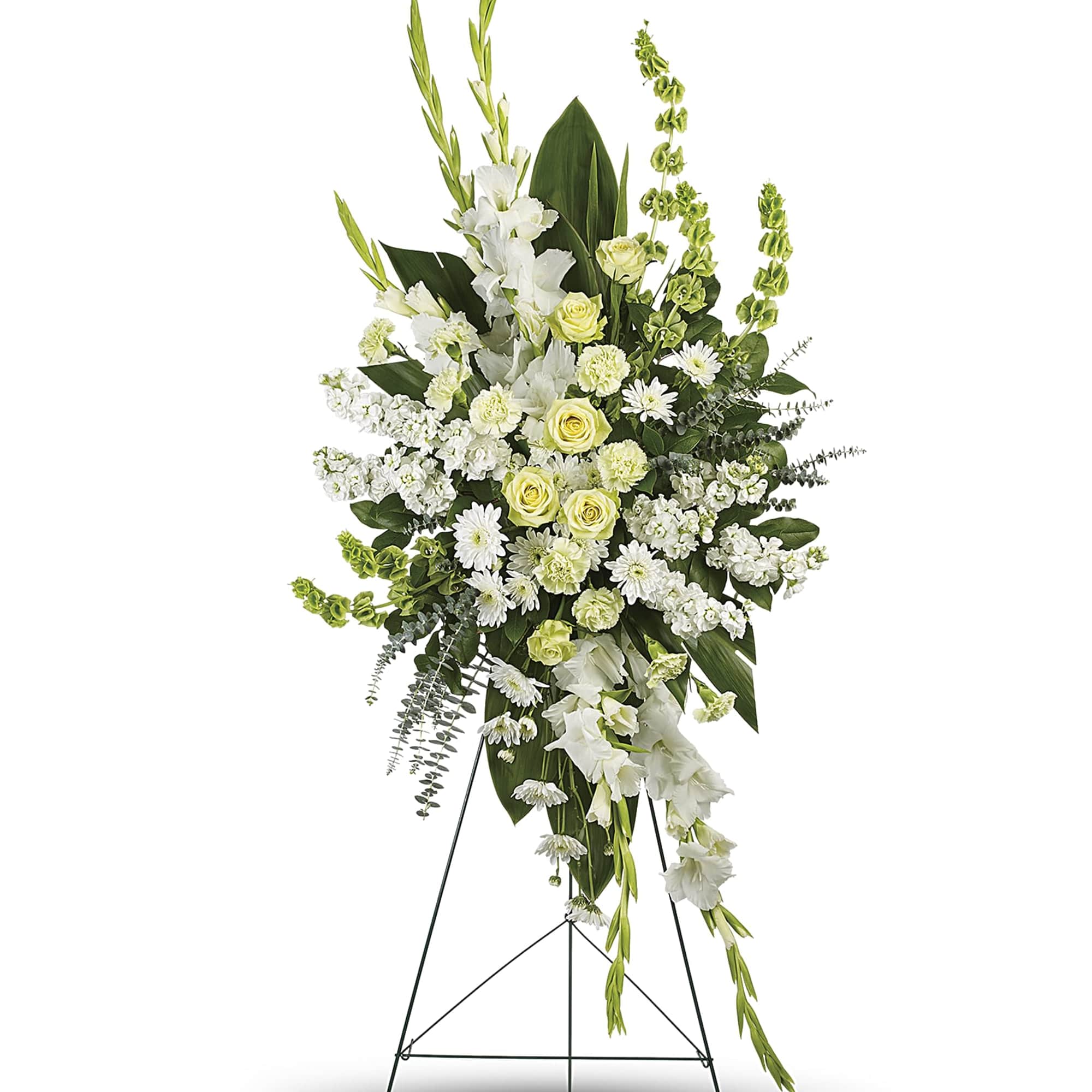 Tall white and soft yellow standing spray with roses and gladiolus on a metal easel