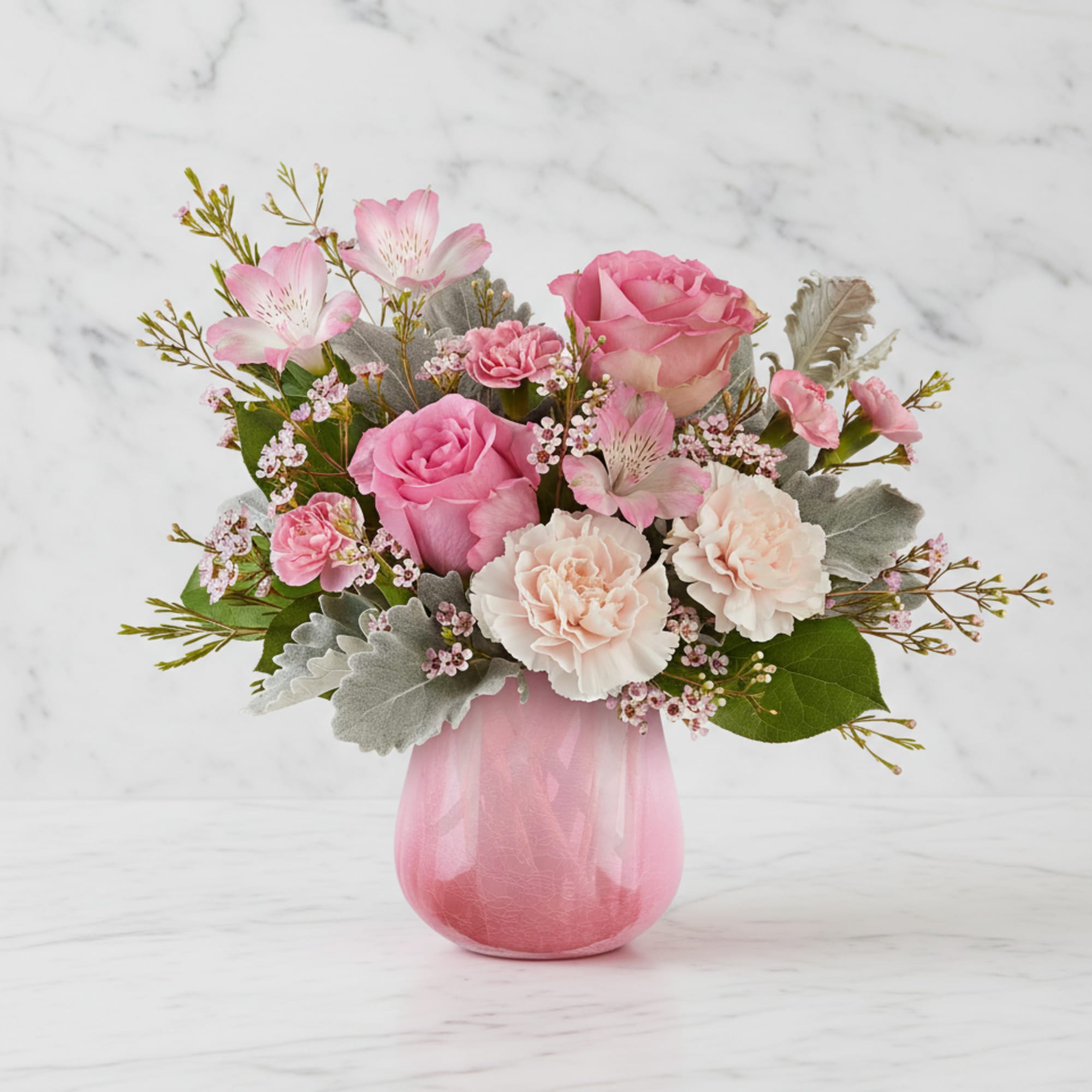 Pink roses and carnations in a pink glass vase