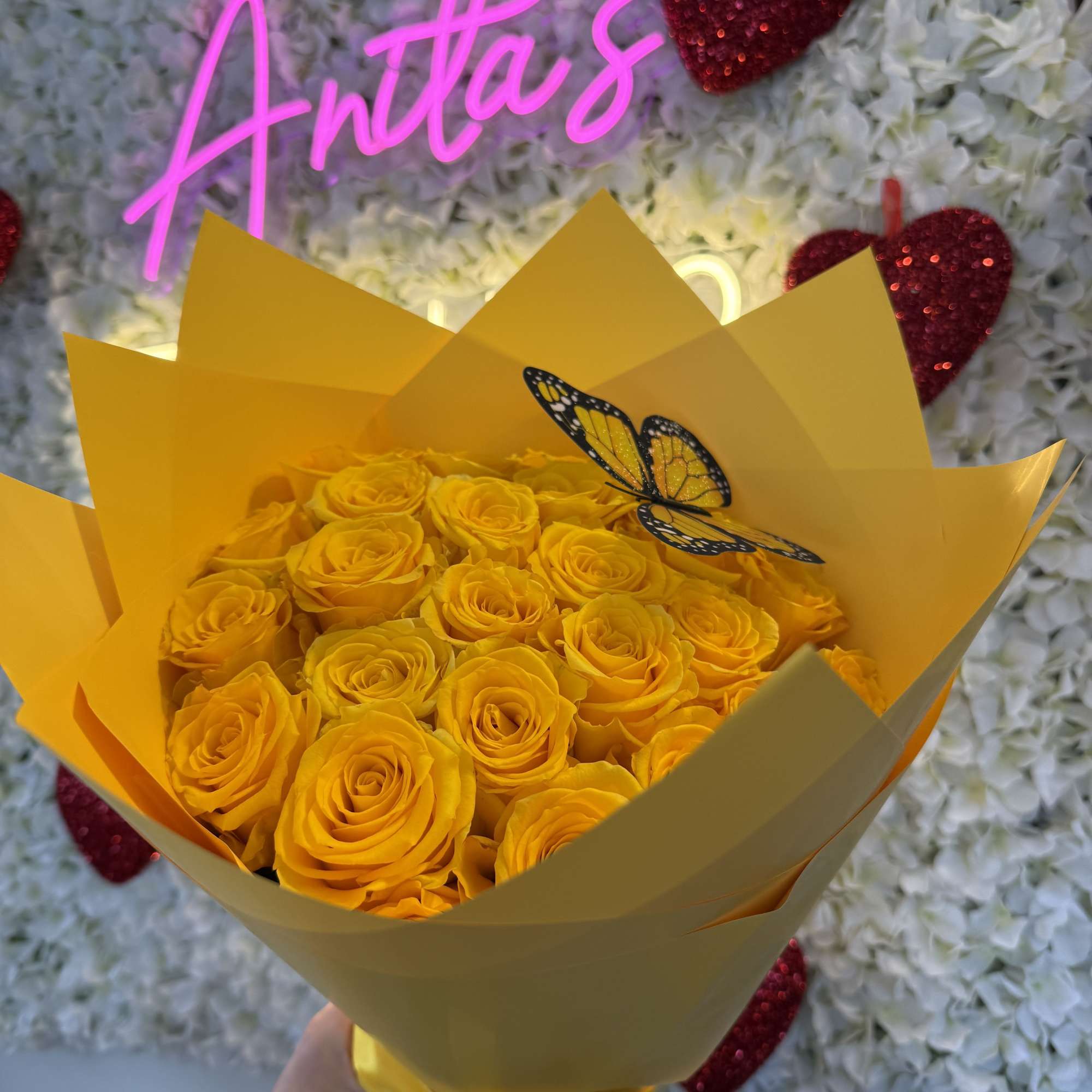 Bouquet of yellow roses wrapped in yellow paper with a butterfly pick