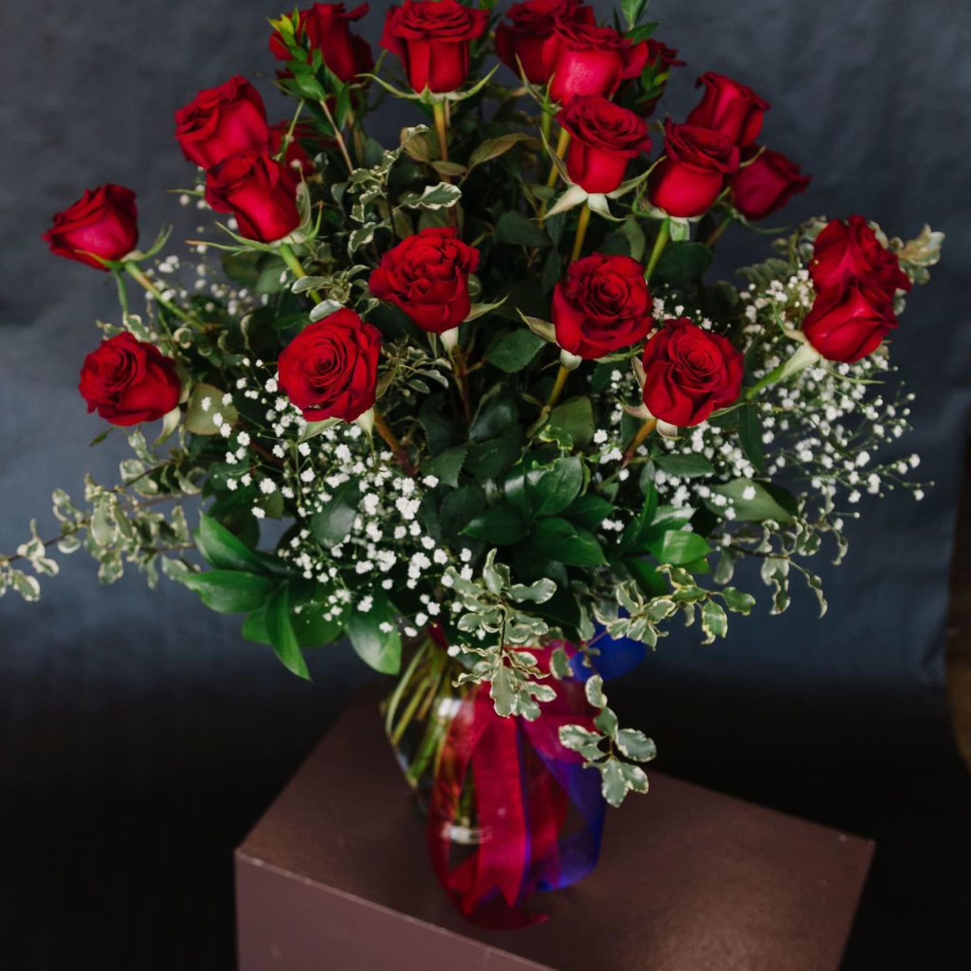 Bouquet of red roses in a glass vase with baby's breath