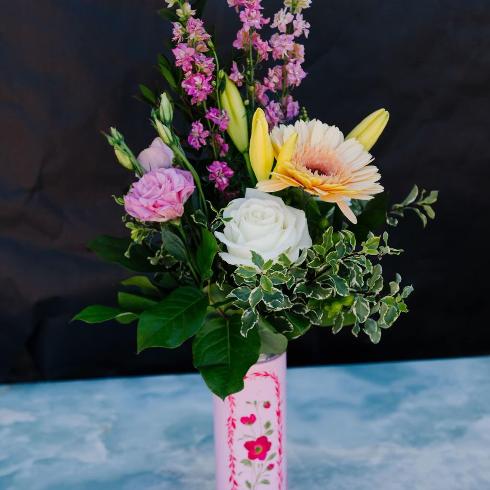 A soft, garden-style mix of seasonal blooms in blush, ivory, and warm