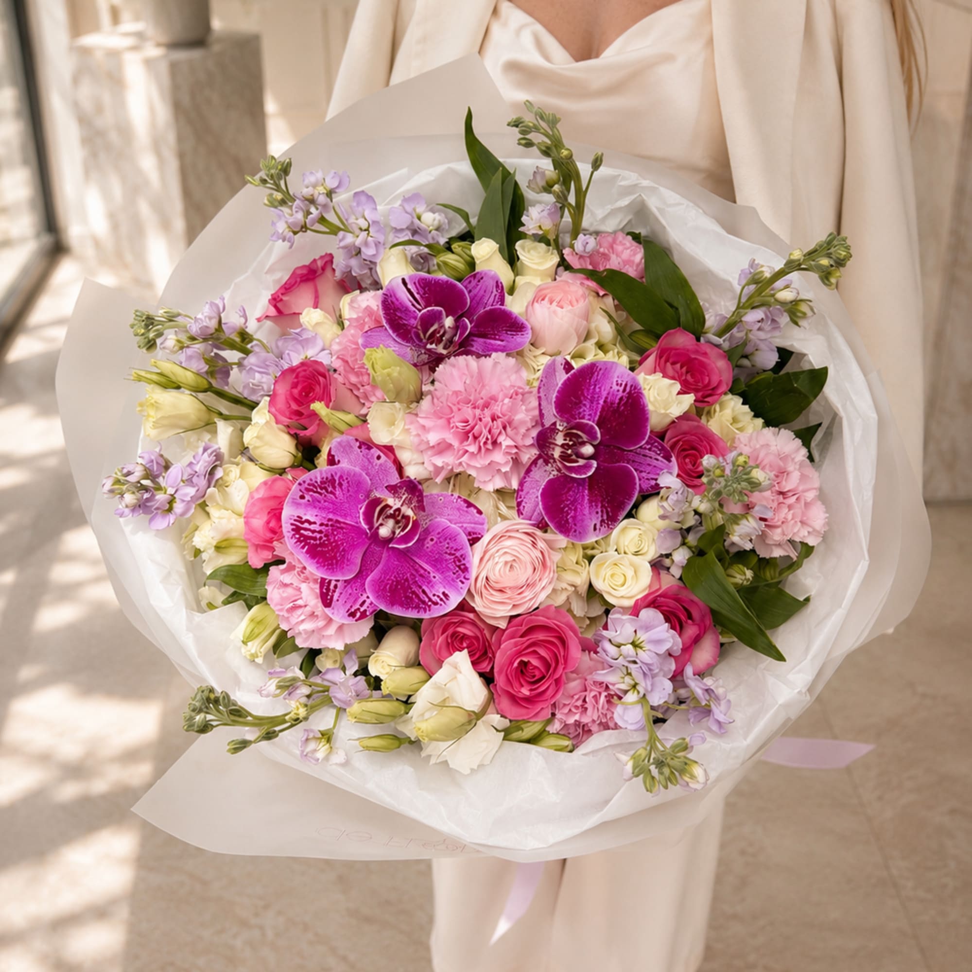 Large bouquet of pink and lavender flowers with orchids and roses