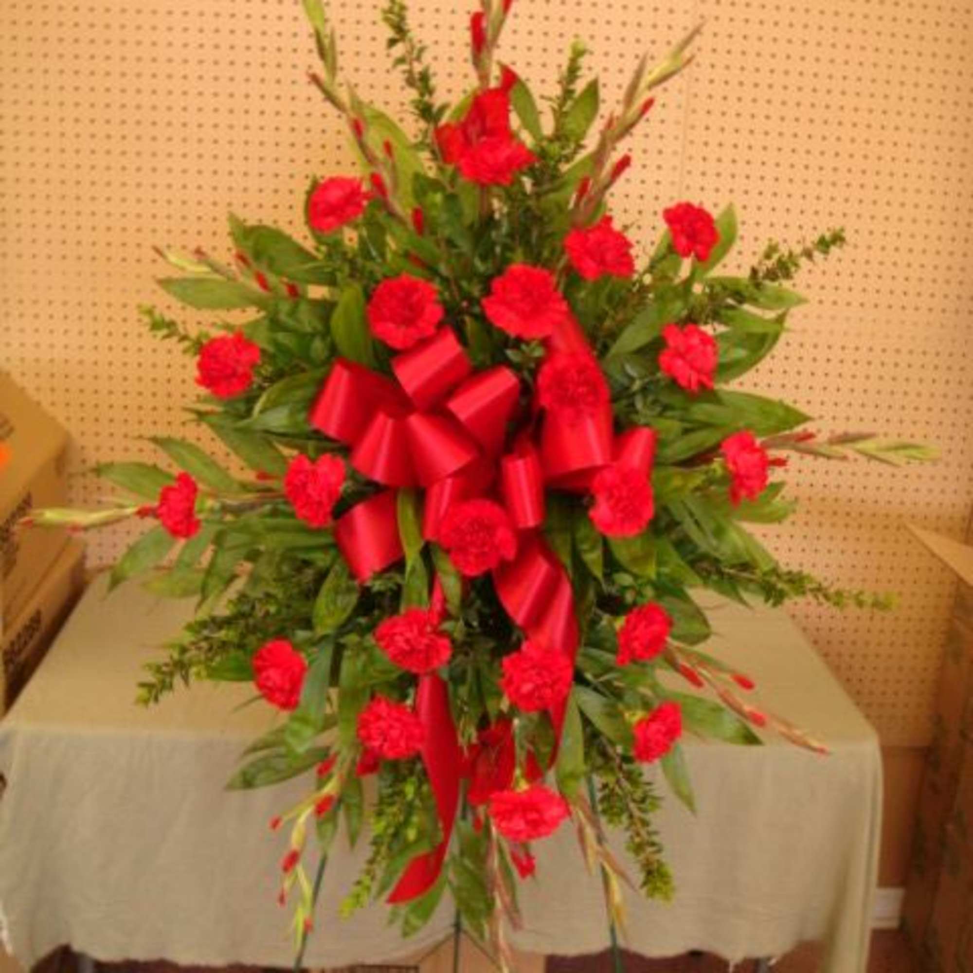 Tall red carnation spray with a large red ribbon
