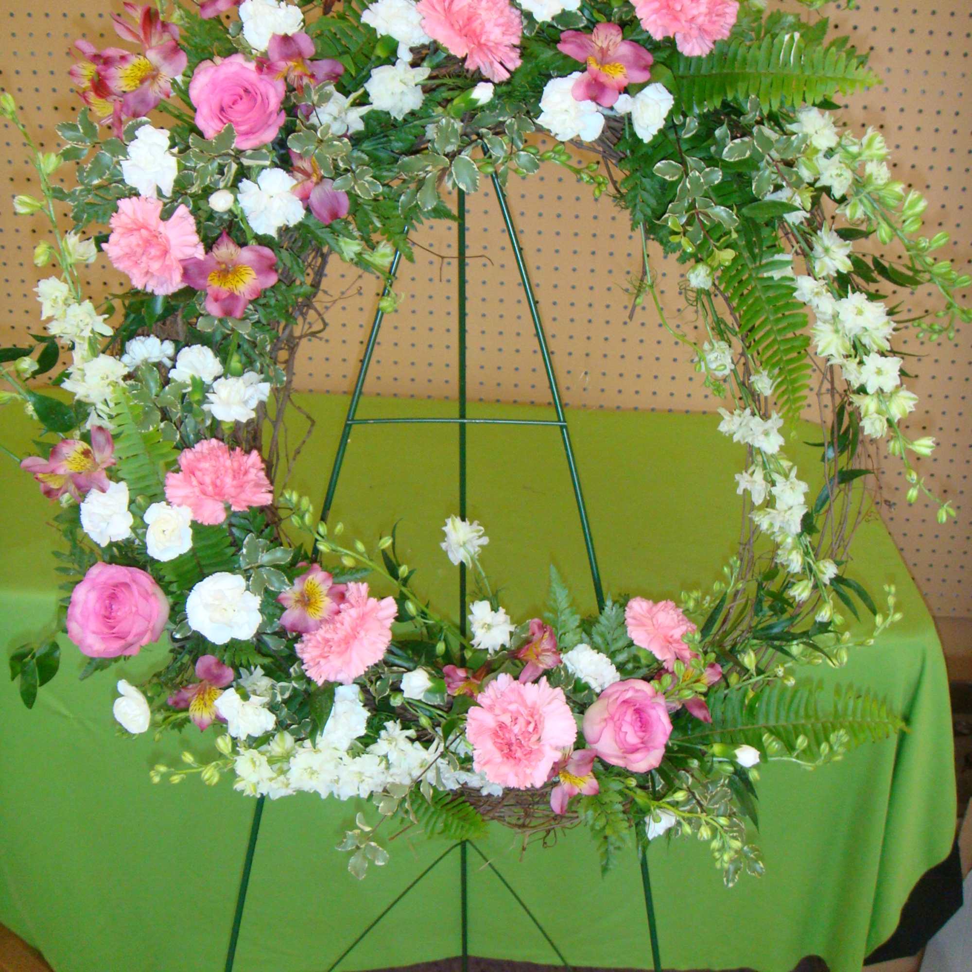 Pink and white floral wreath on a metal stand
