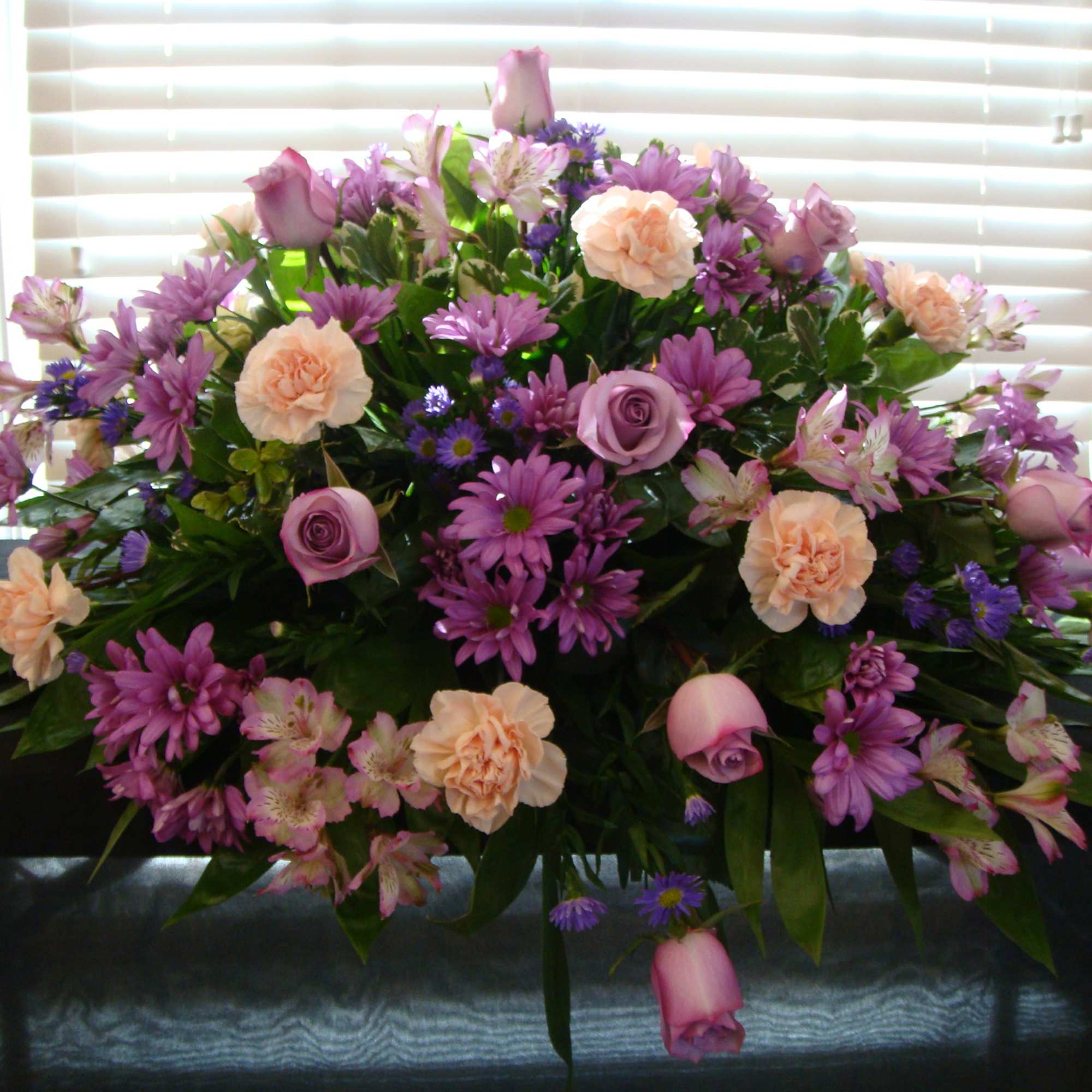 Large bouquet of purple and peach flowers on a table