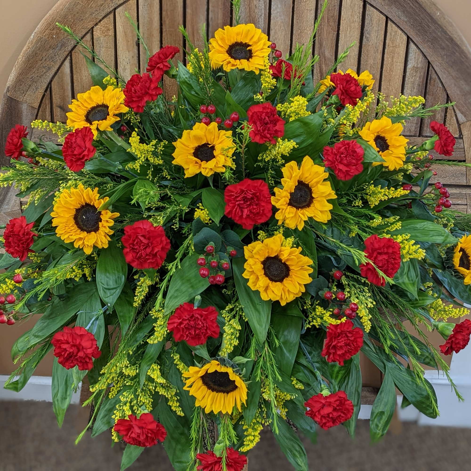 Sunflower and red carnation arrangement in a wooden container