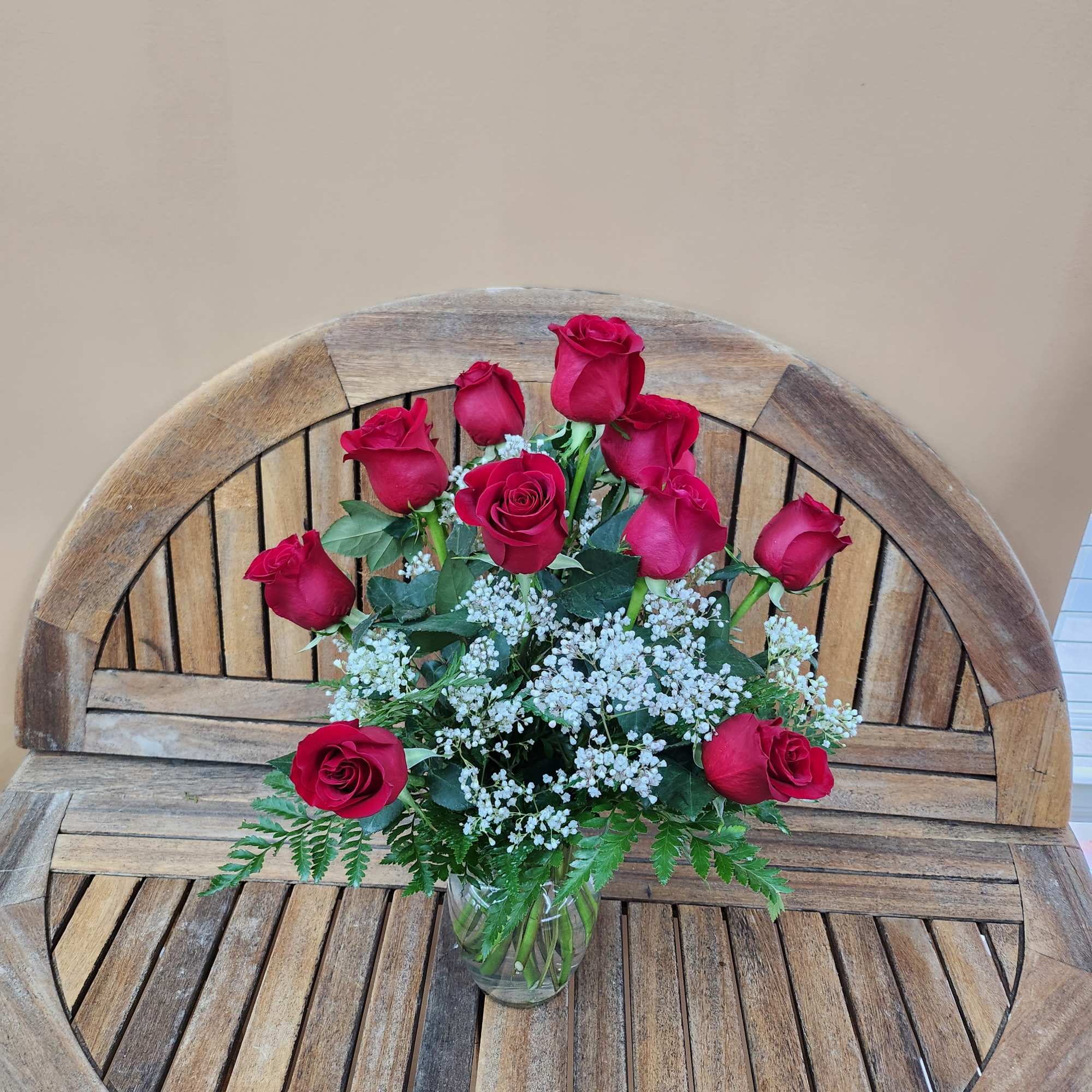 Bouquet of red roses and white filler flowers in a glass vase