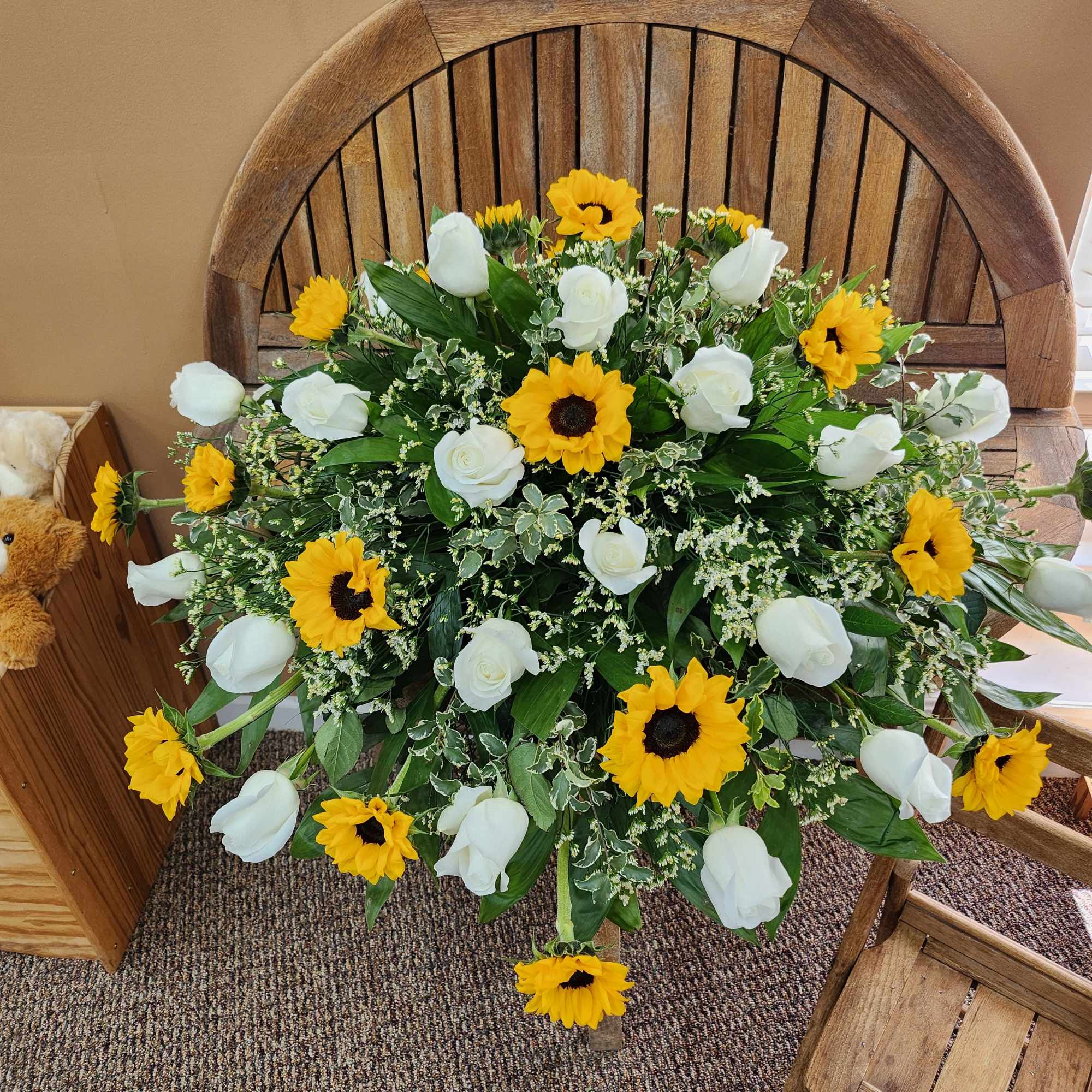 Casket cover with sunflowers, white roses, greenery and filler
