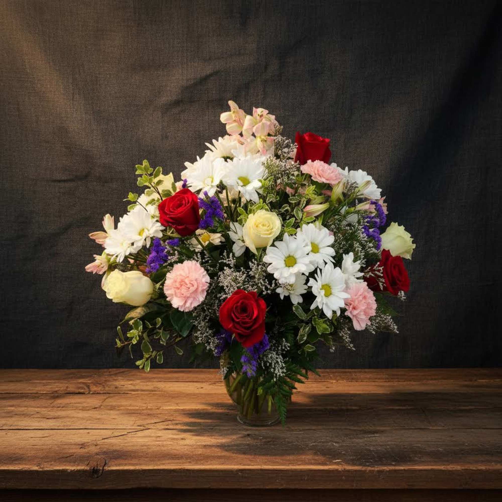 Mixed arrangement of roses, carnations,  daisies, and alstroemeria.