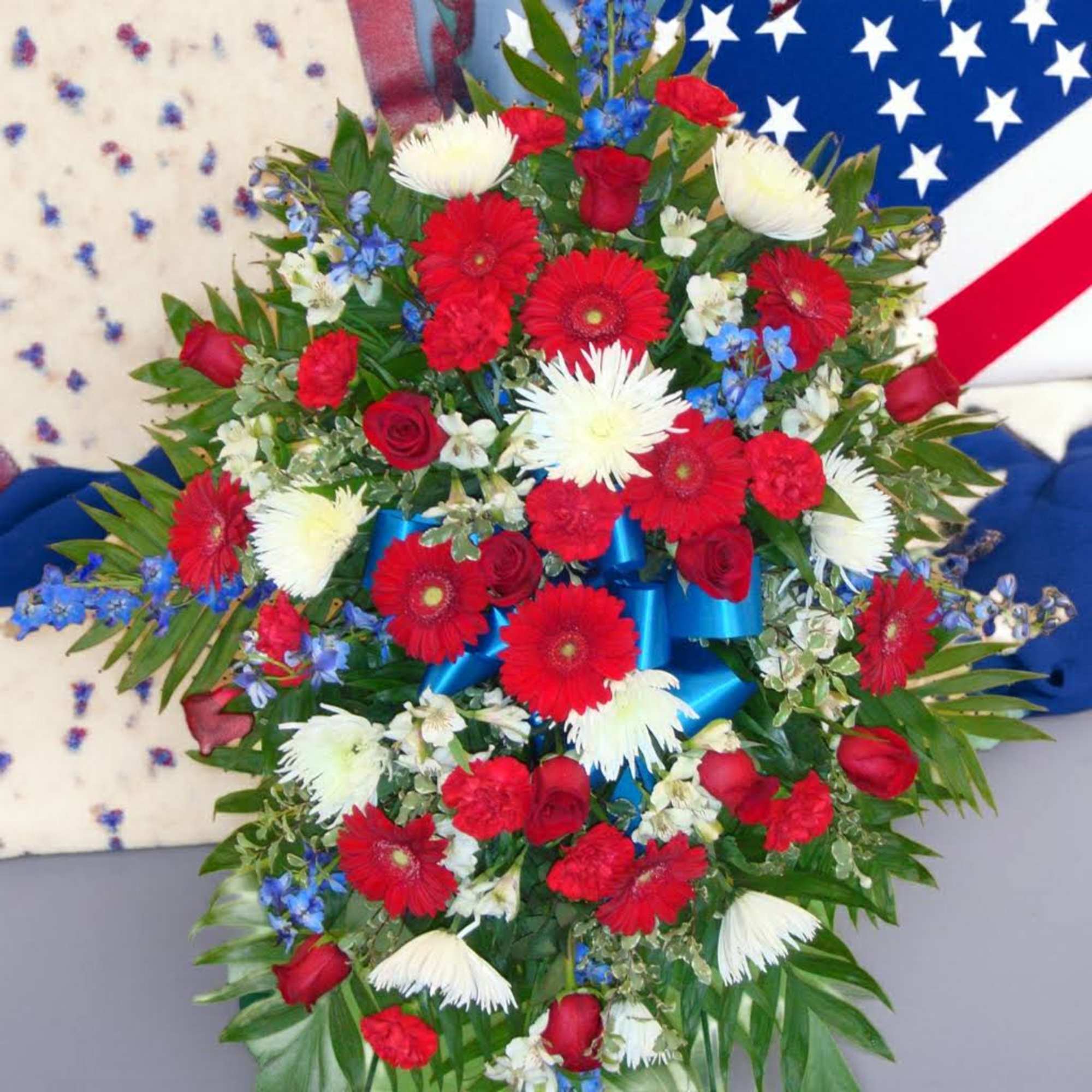 Large red, white, and blue floral spray with ribbon