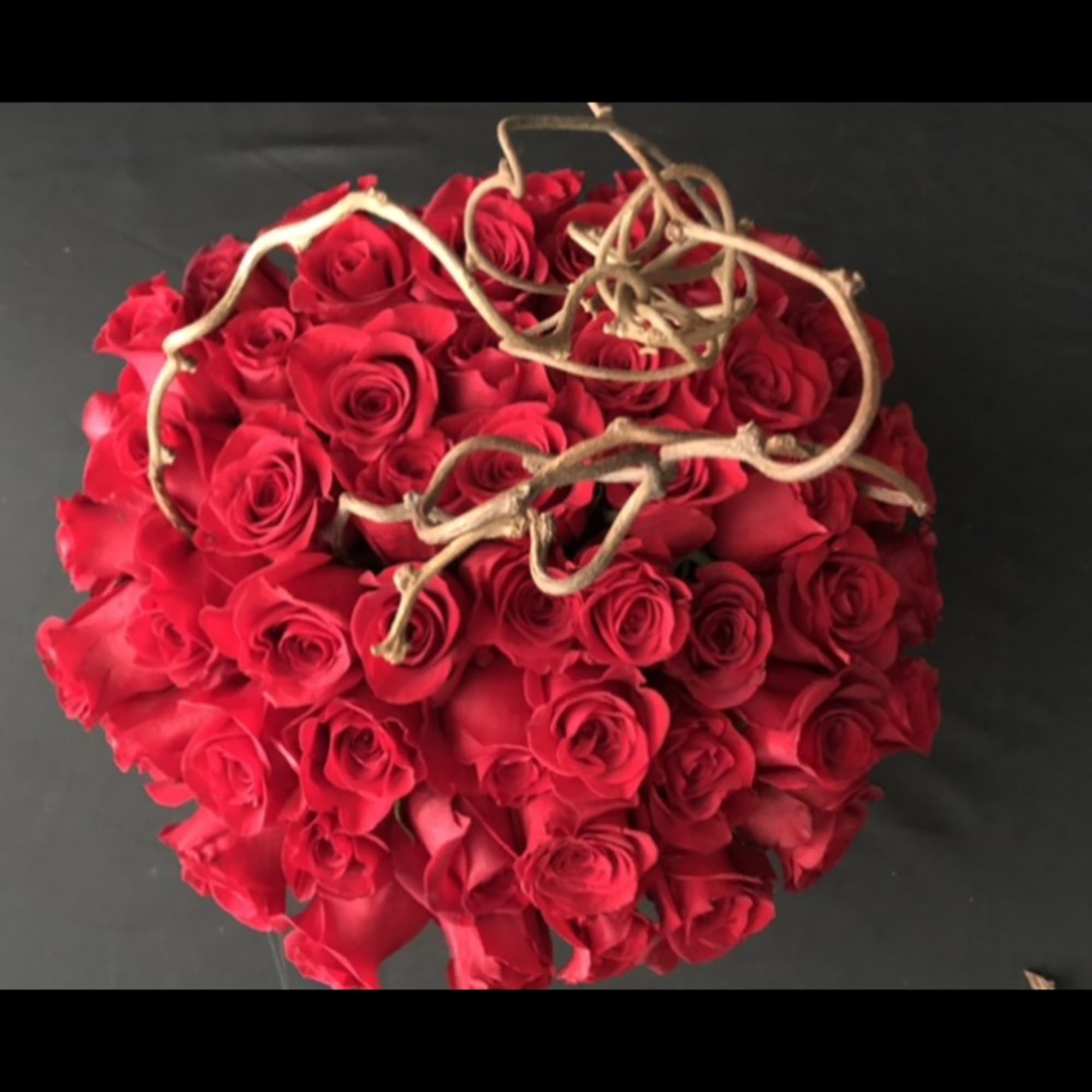 Round bouquet of red roses with curly twig accents