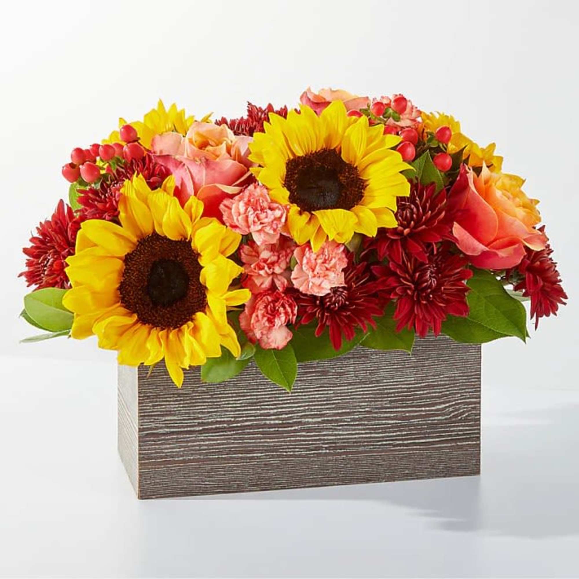 Sunflowers and red flowers arranged in a rectangular wooden box