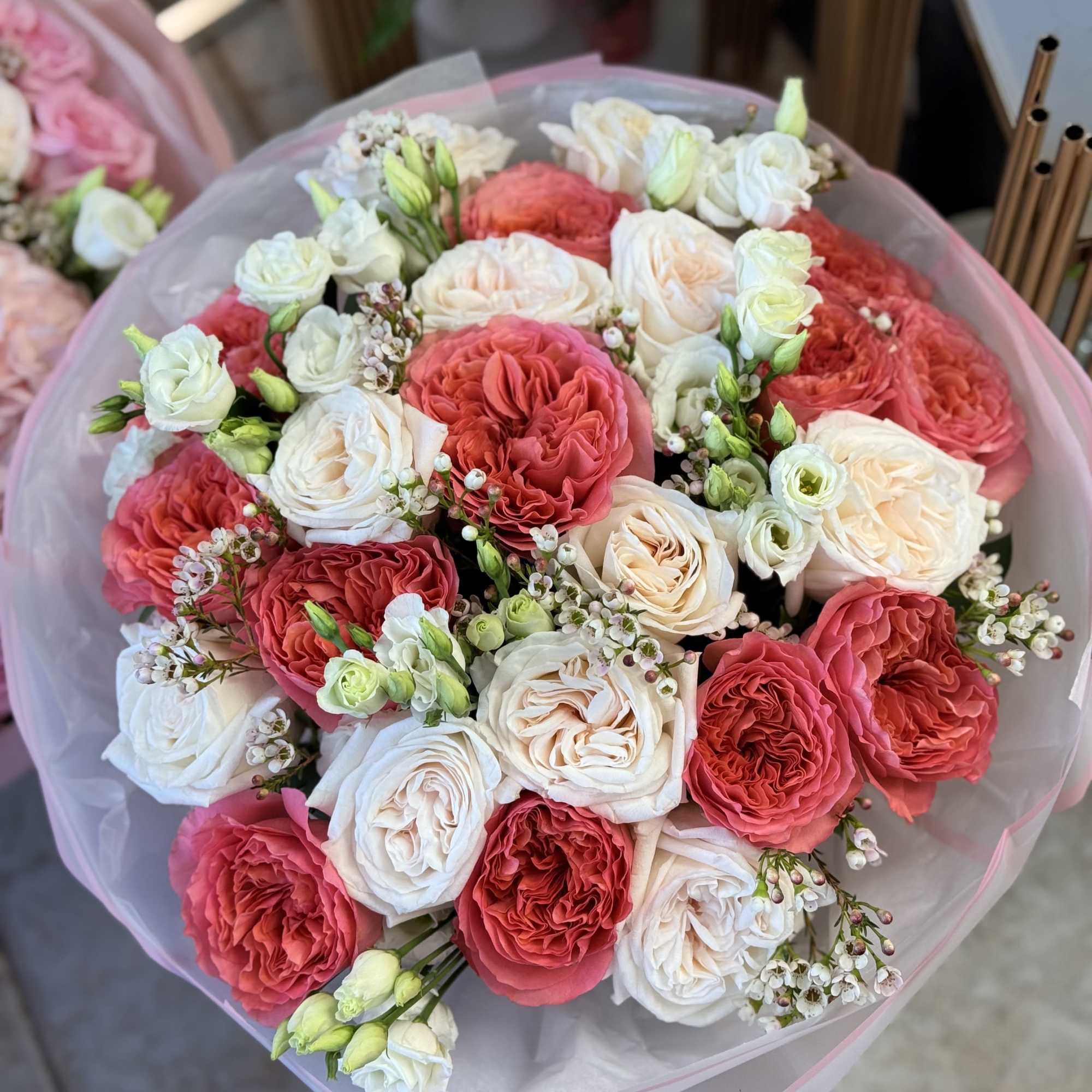 Bouquet of pink and white roses wrapped in pale pink paper