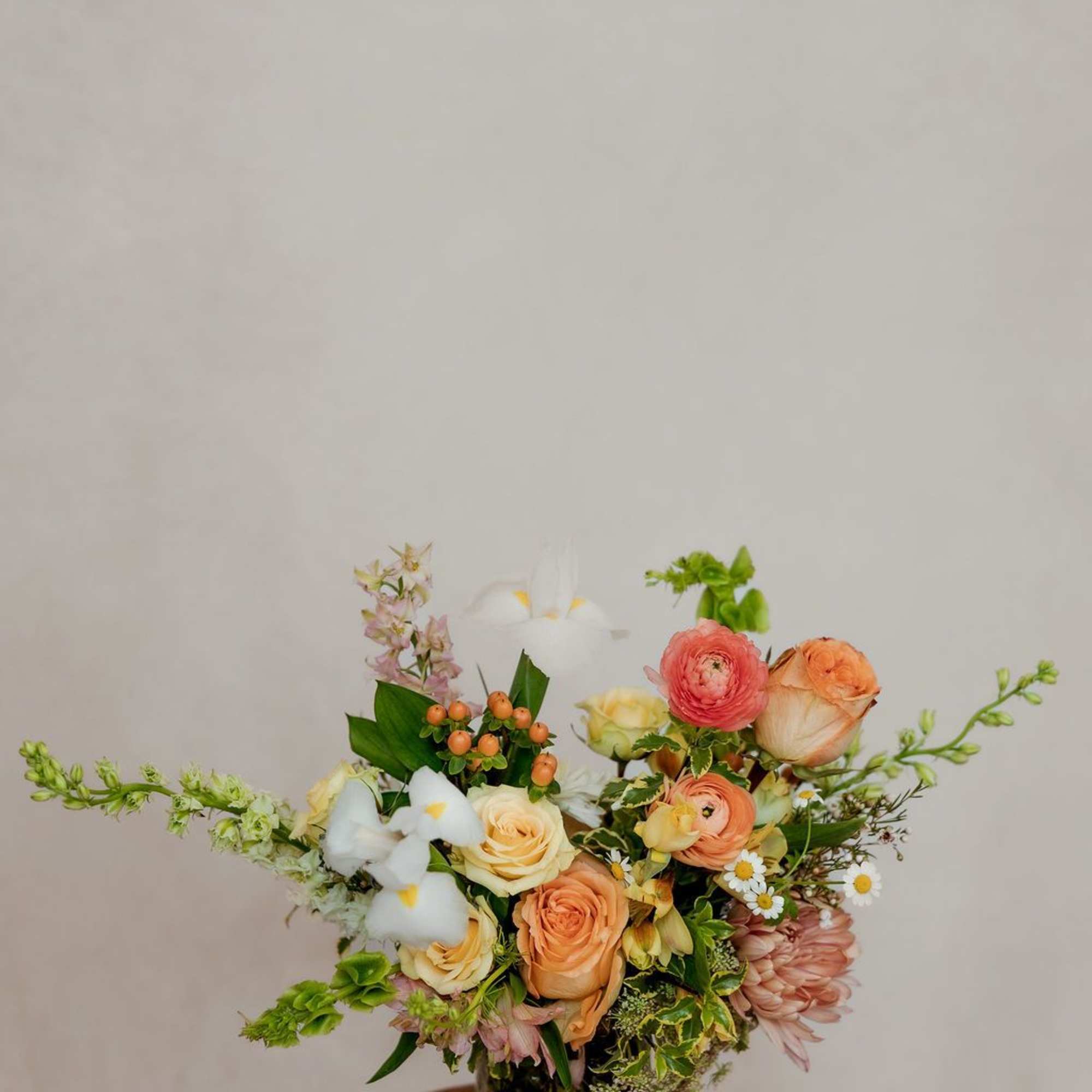 Mixed bouquet in a glass vase with peach, white, and pink blooms