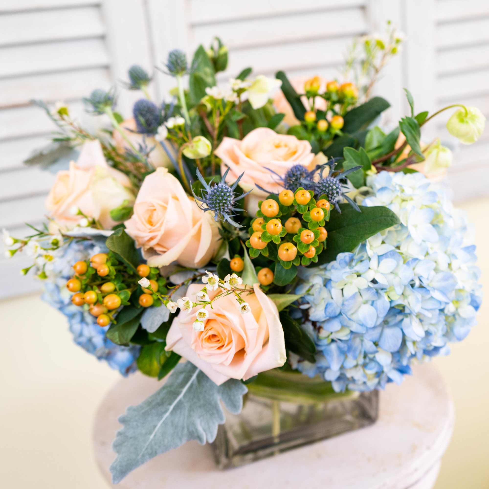 Bouquet of peach roses and blue hydrangeas in a glass vase, photo 3 of 4
