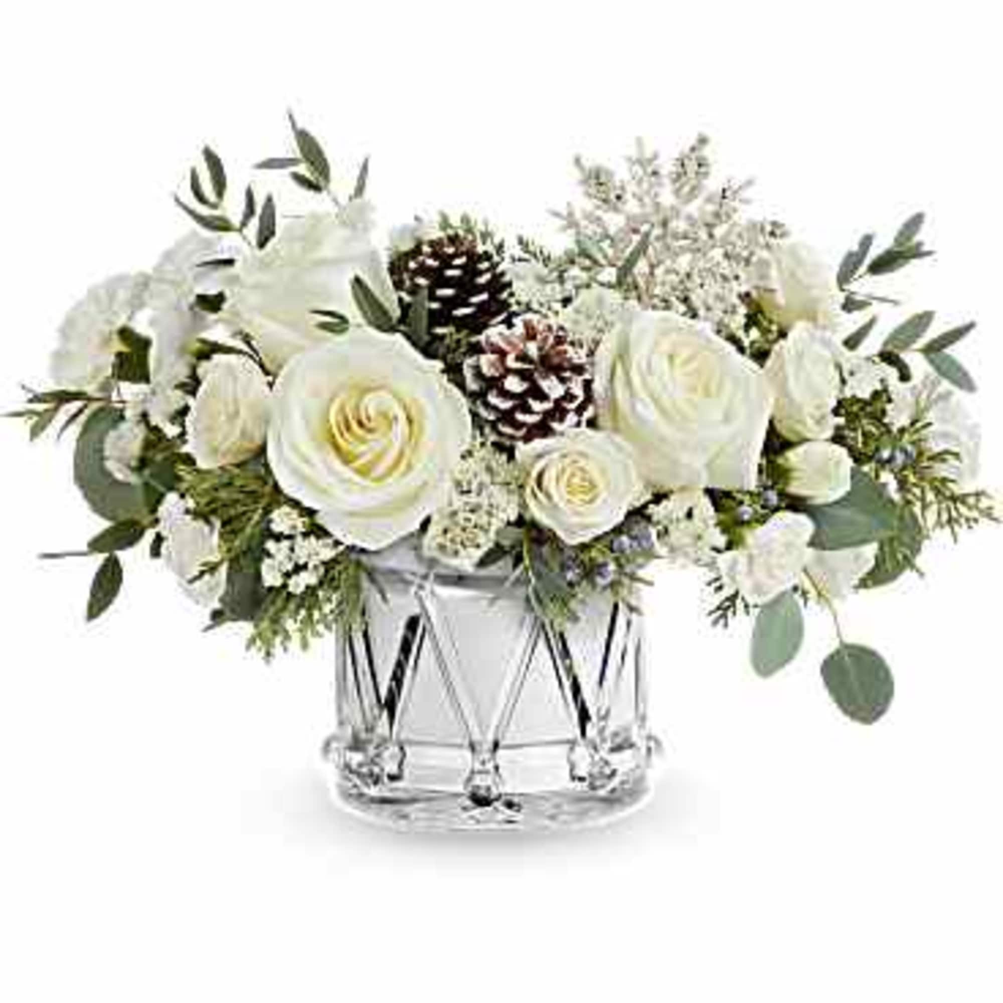 White roses and pinecones in a clear glass vase