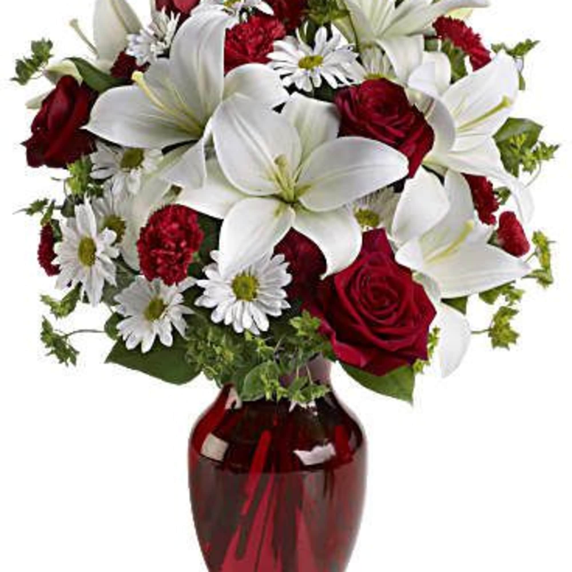 Red roses and white lilies in a red glass vase