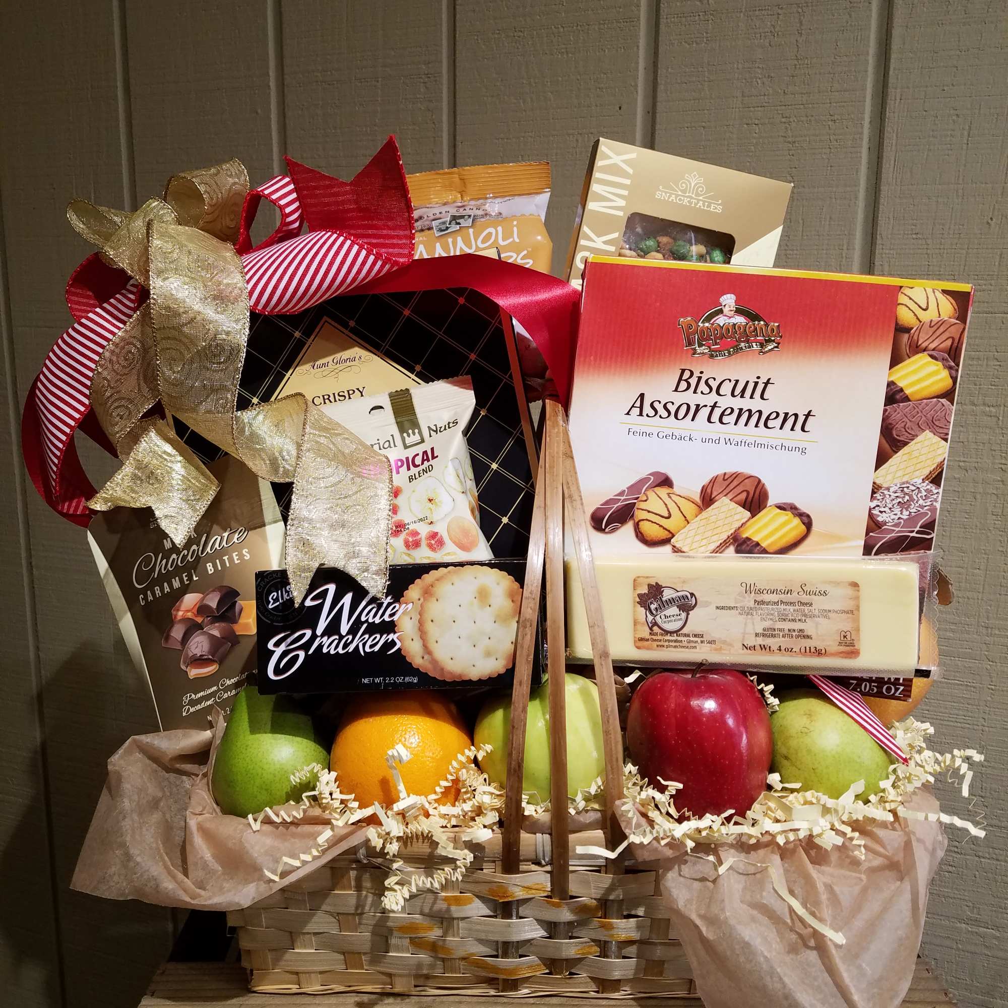 Gift basket with snacks, fruit, and ribbon bows