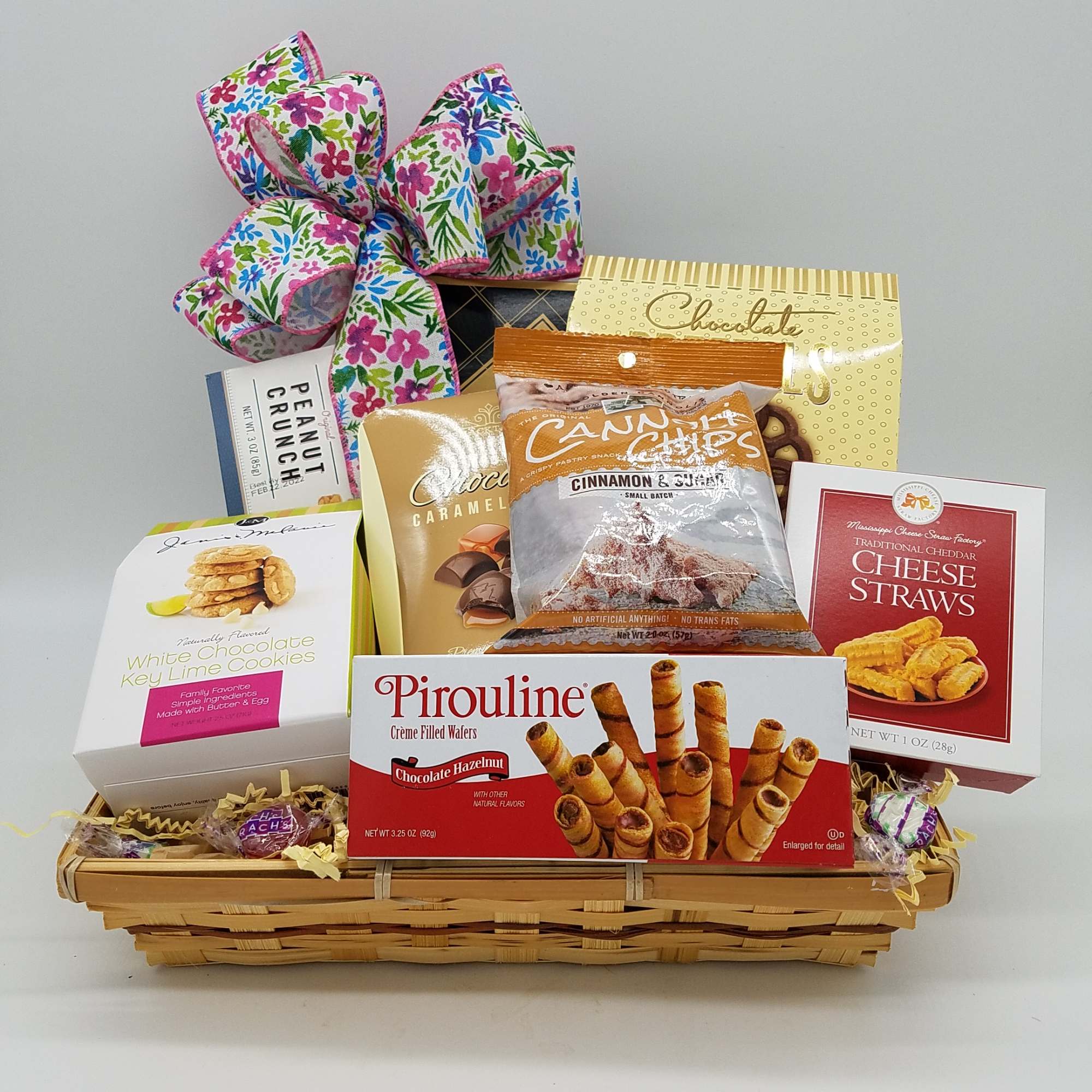Gift basket with assorted snack boxes and a floral ribbon bow