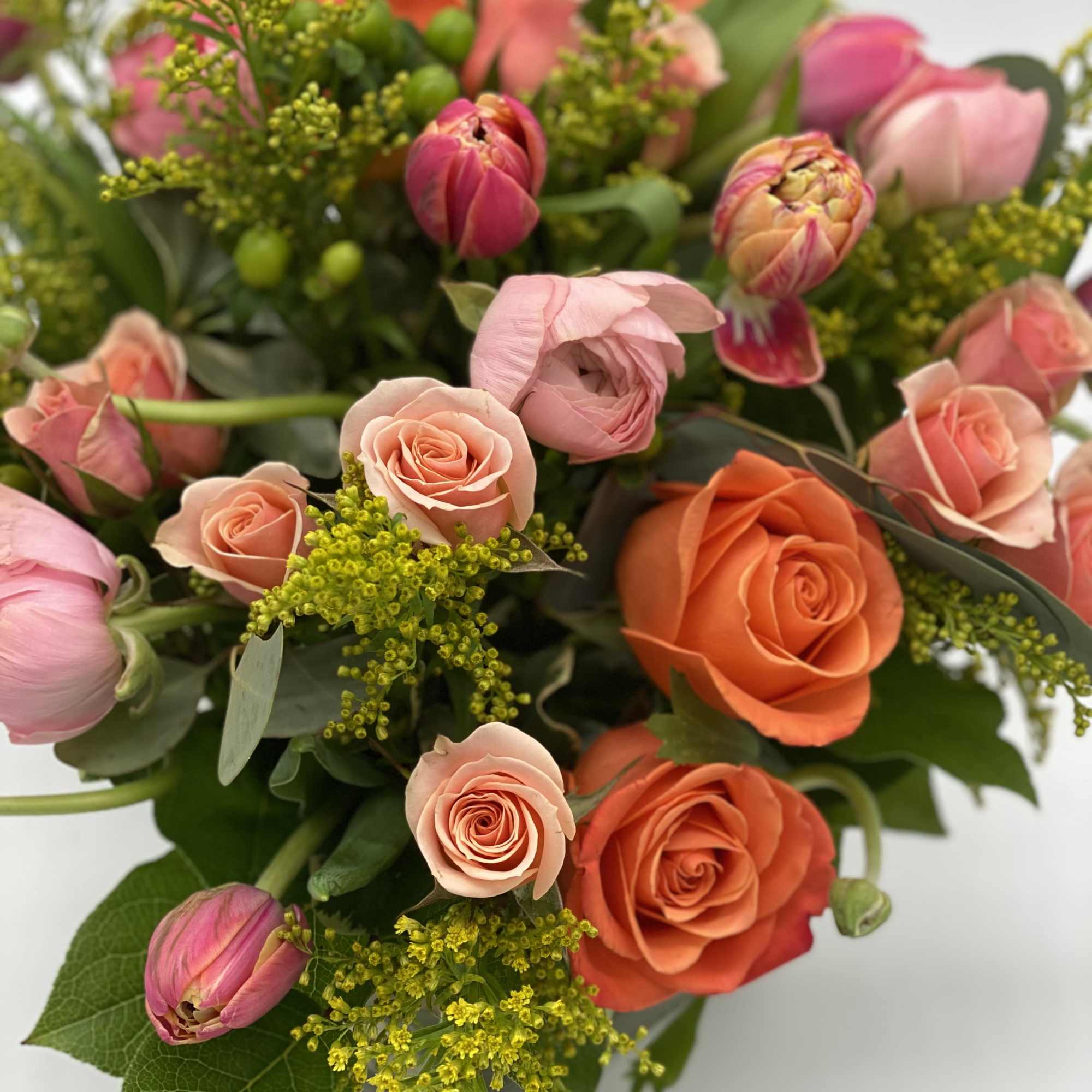 Bouquet of pink and orange roses with tulips and yellow filler flowers