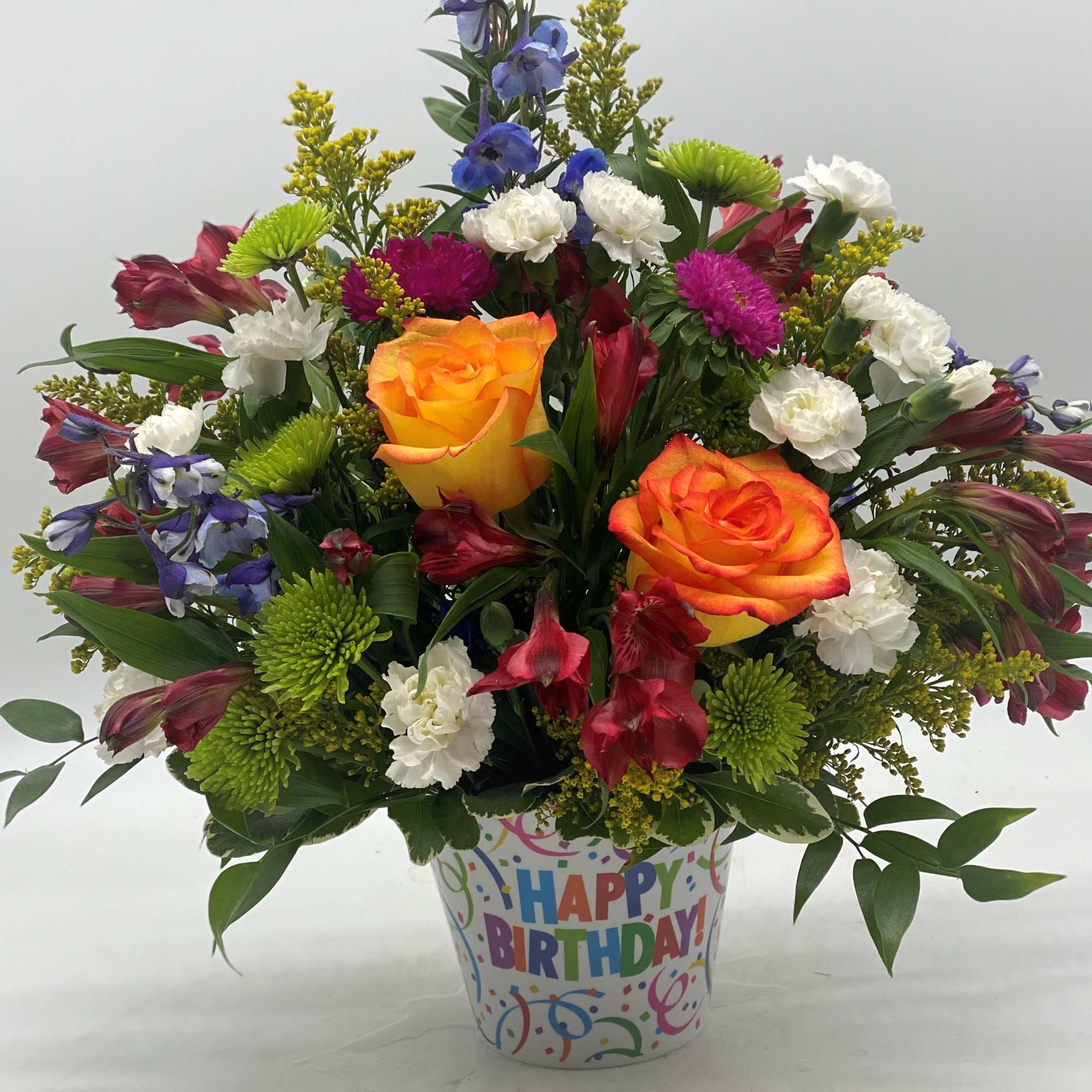 A bright mix of fresh cut flowers designed in a hard plastic