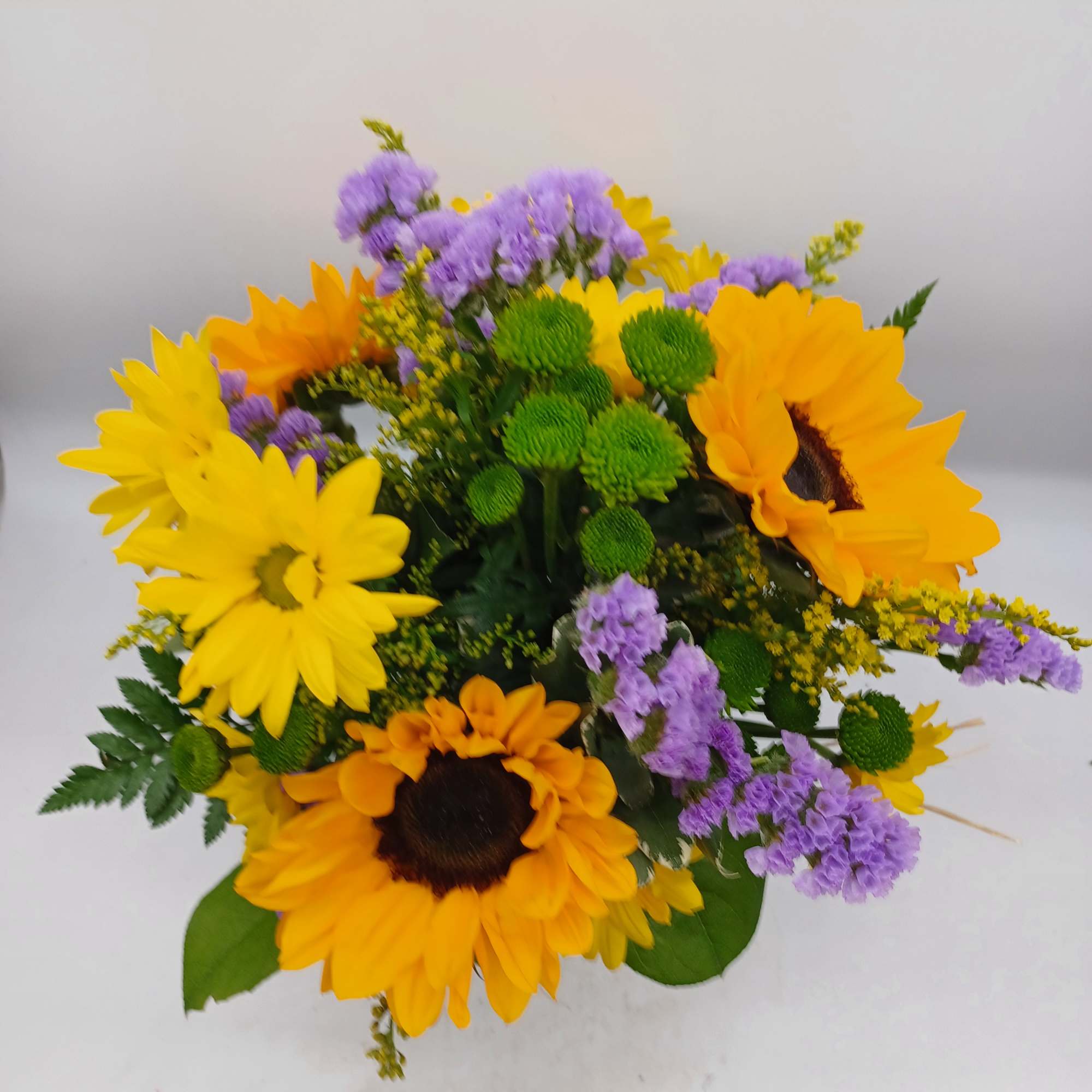 Bouquet of yellow sunflowers and purple filler flowers