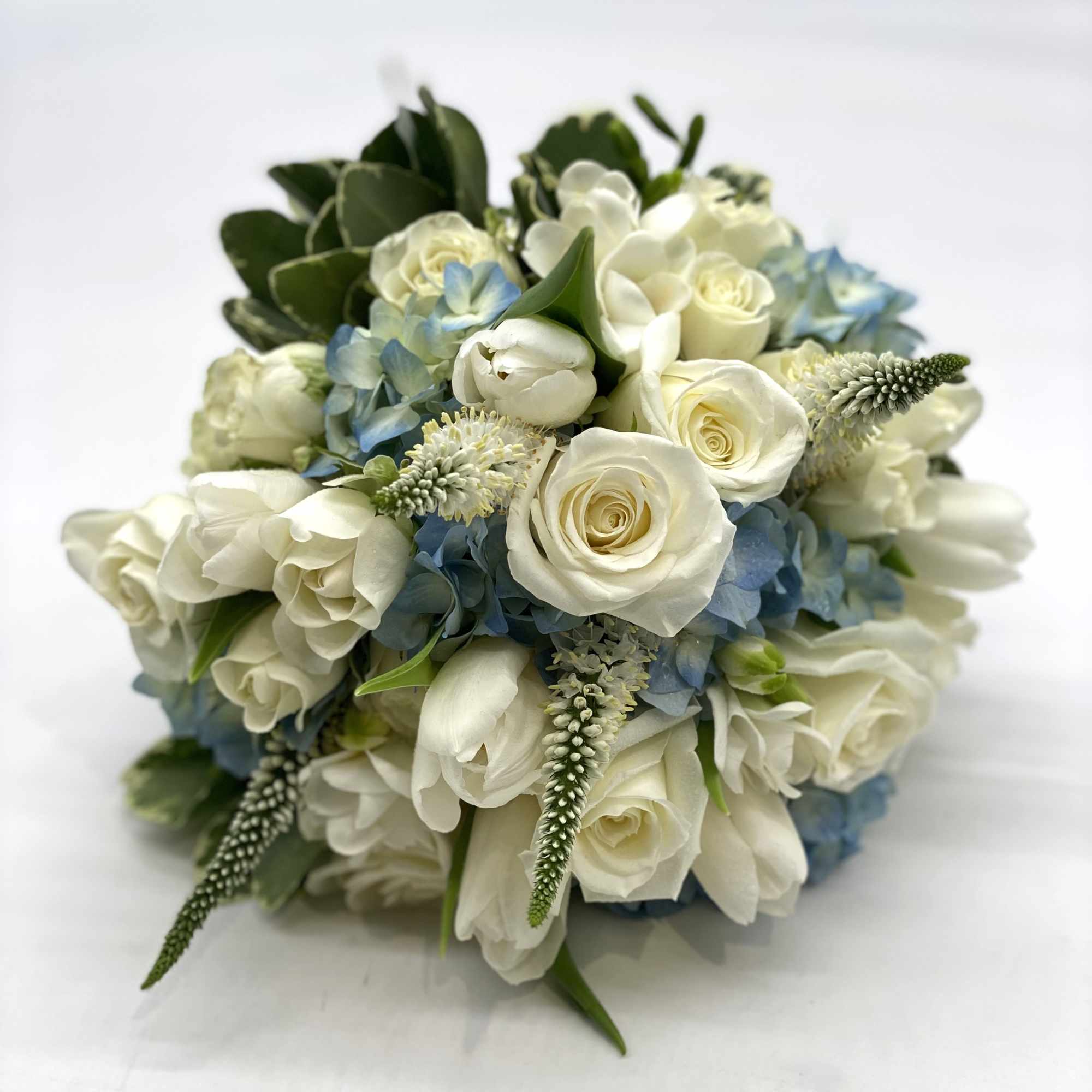A lush mix of white flowers designed within a blue hydrangea. 