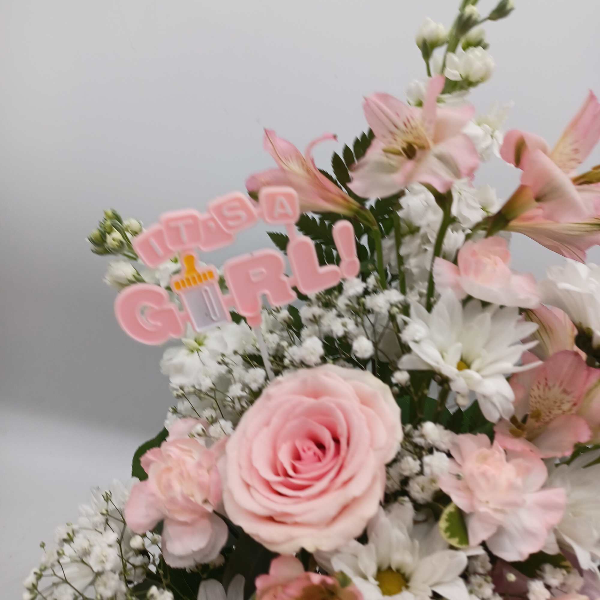 Pink and white bouquet with a "It's a GIRL!" topper