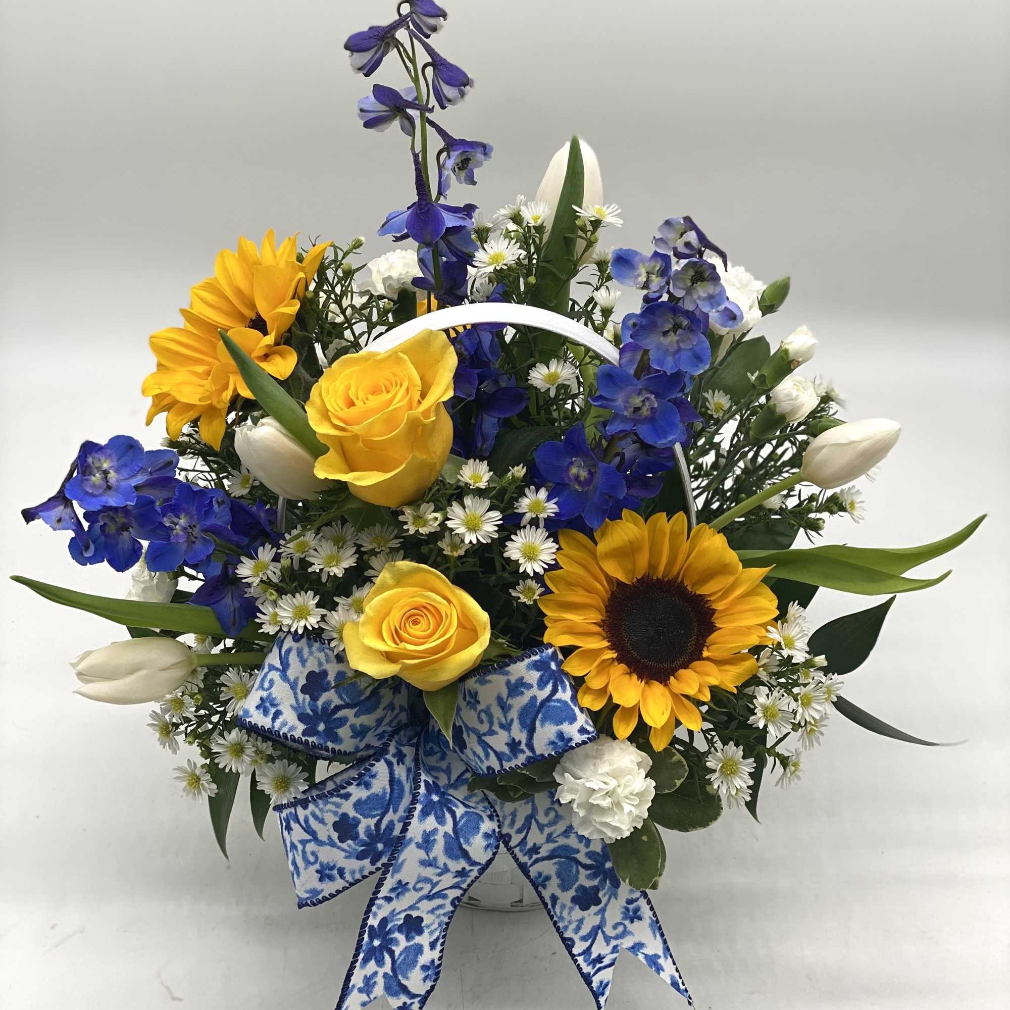 Basket arrangement with yellow roses, sunflowers, blue flowers, and white tulips, photo 4 of 5