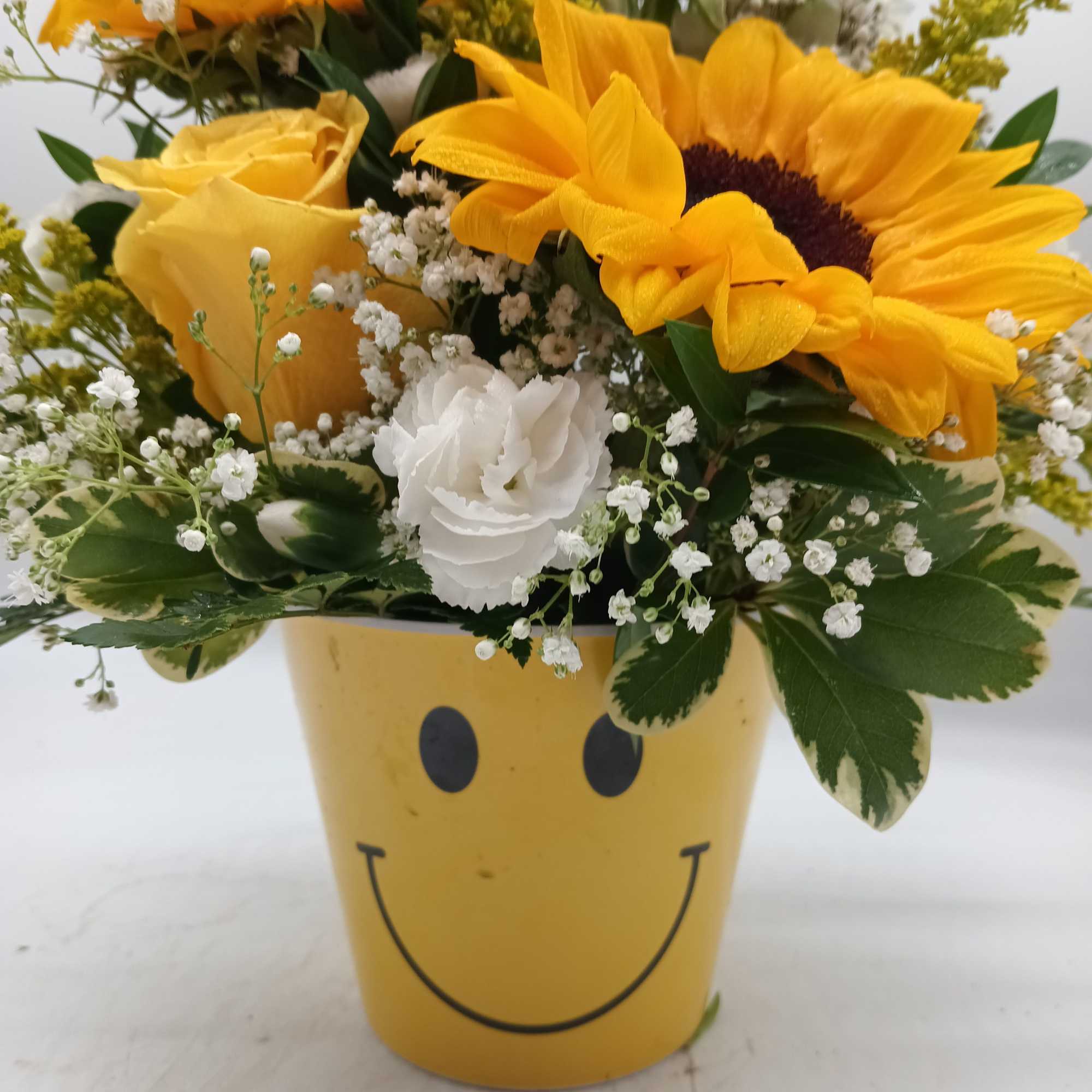 Yellow sunflower and rose bouquet in a smiley-face pot