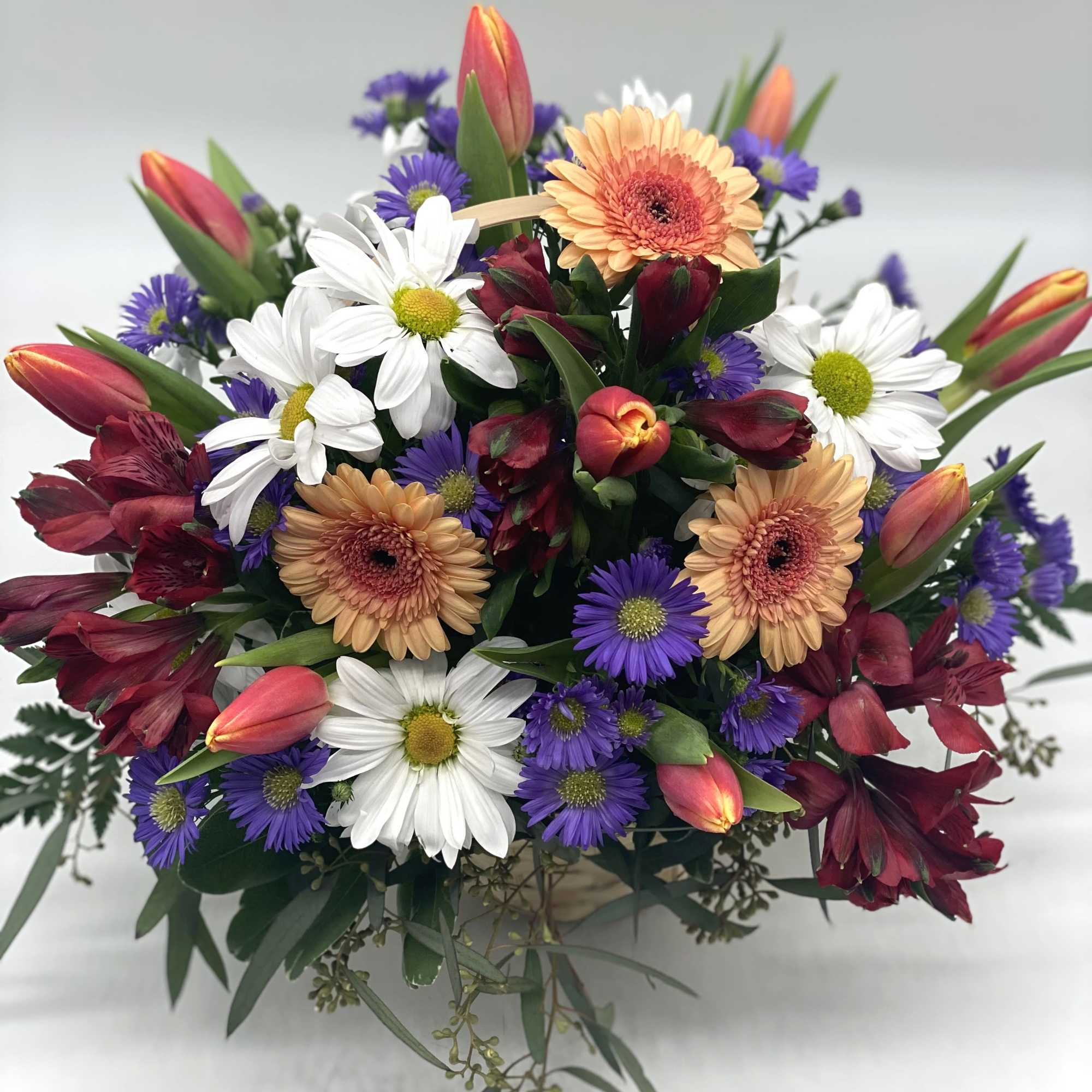 Mixed bouquet with daisies, gerbera daisies, tulips, and purple asters