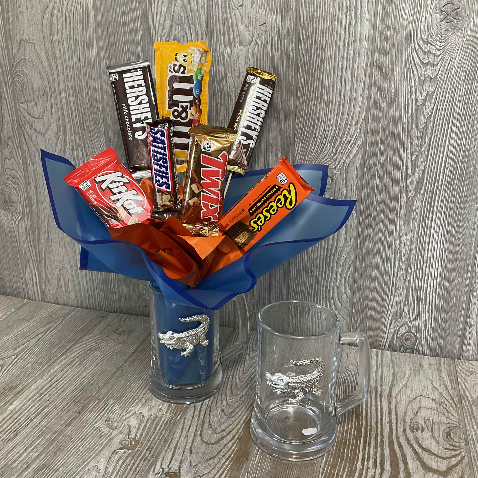 Candy bars arranged in a blue-wrapped mug with a crocodile design