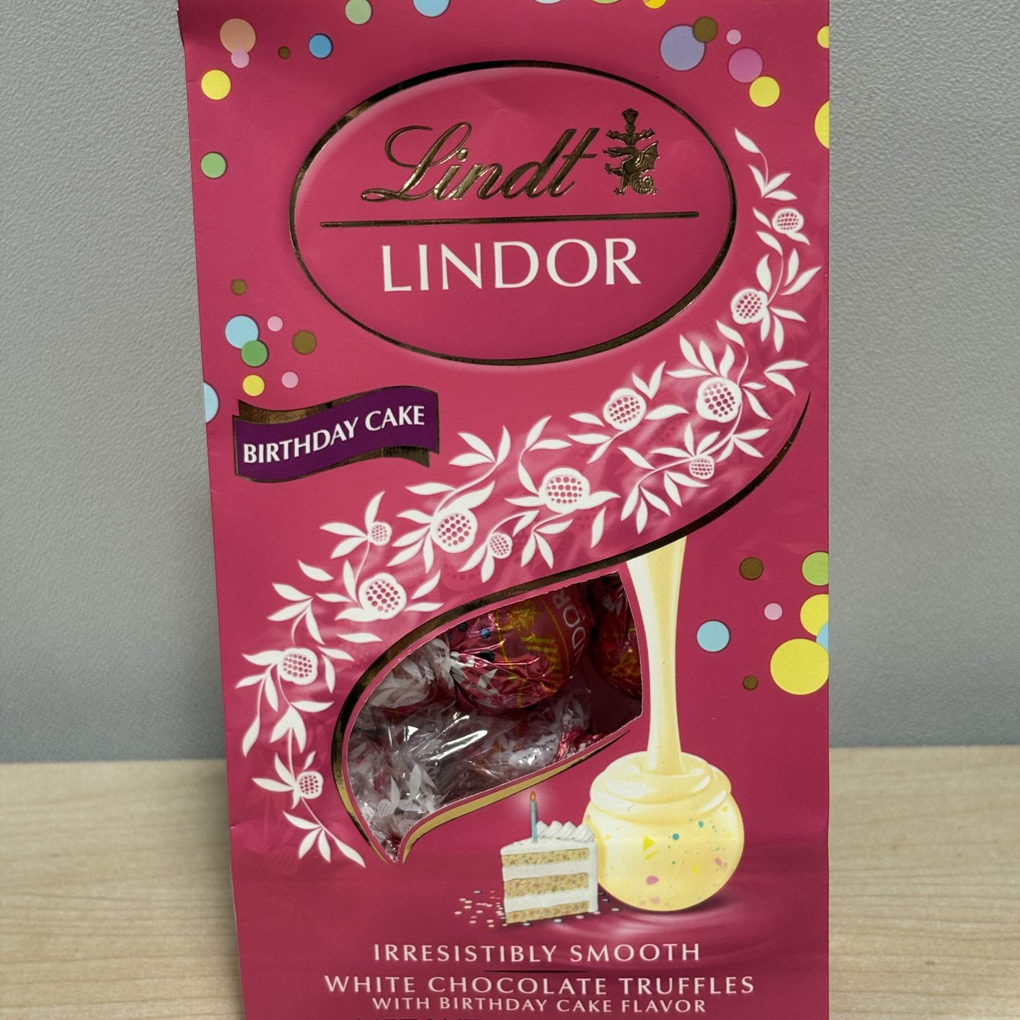 Pink Lindt Lindor birthday cake truffles box with a window showing wrapped chocolates