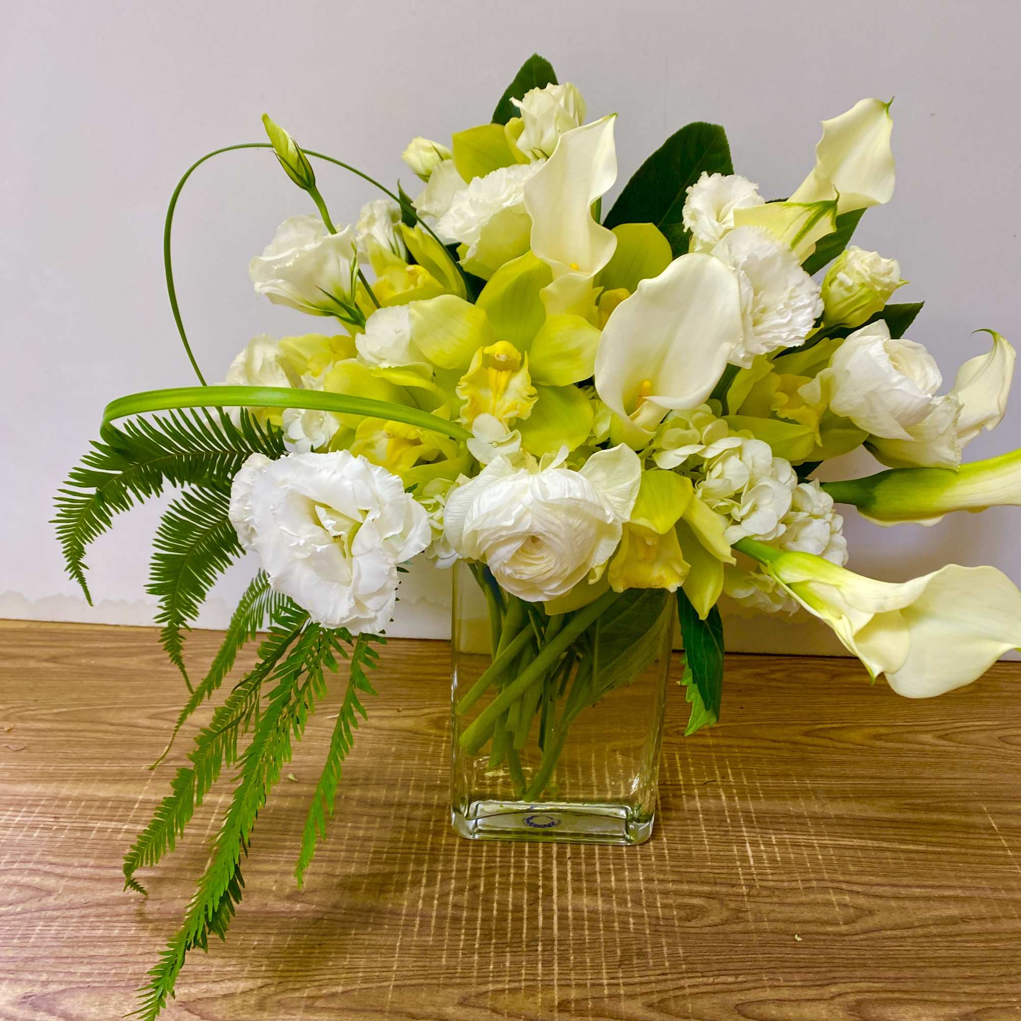 White and yellow flowers arranged in a clear glass vase