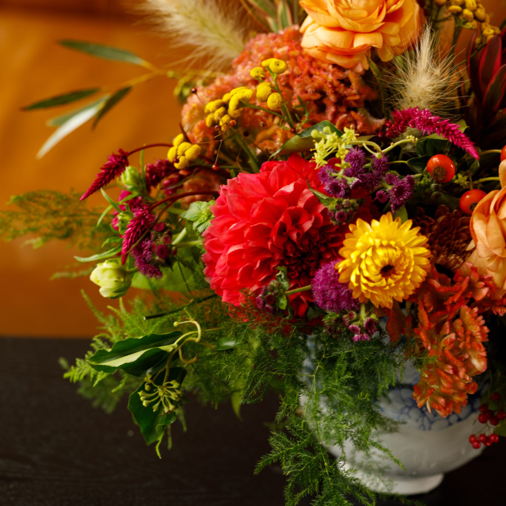 Colorful mixed bouquet in a white vase with red, yellow, orange, and purple blooms