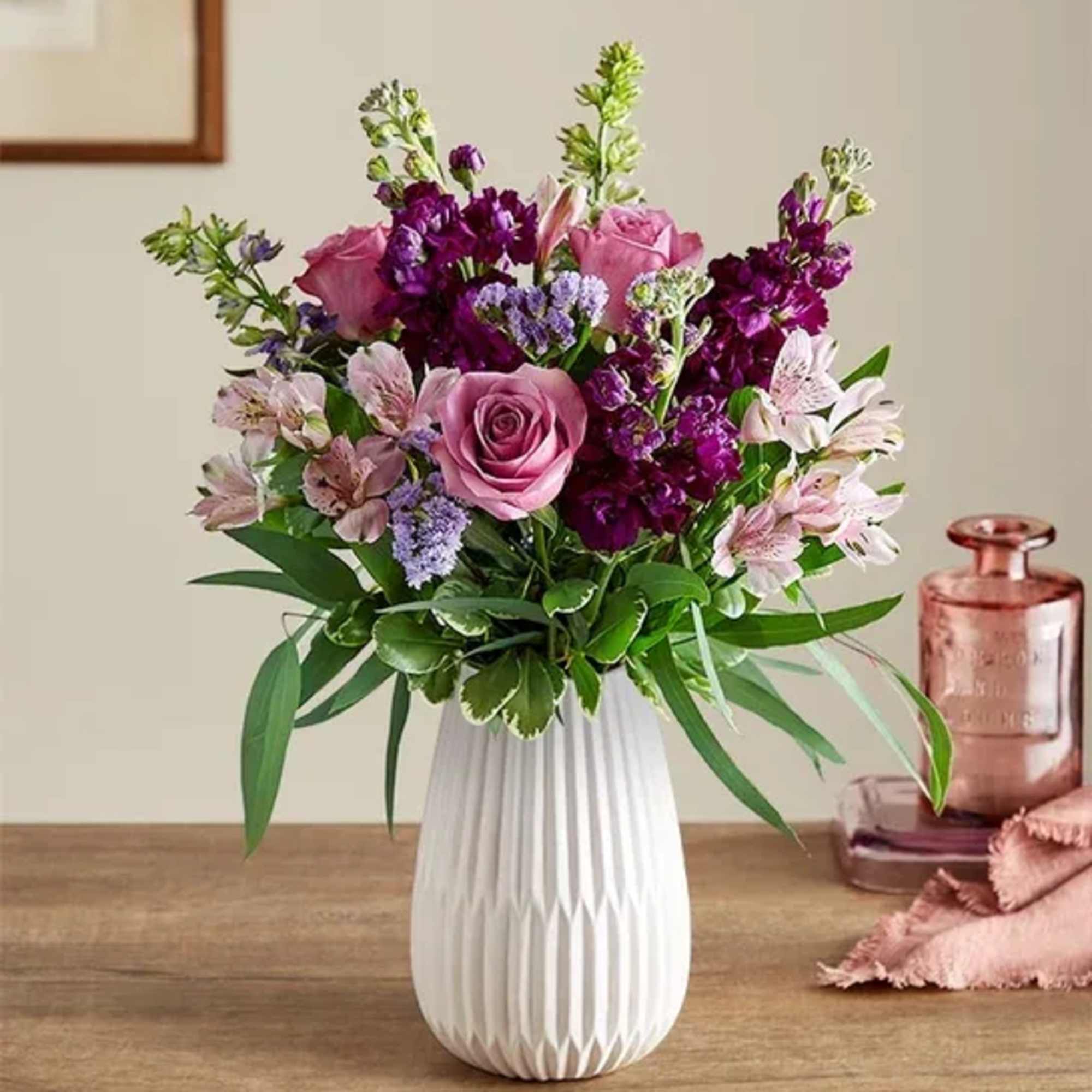 Pink and purple bouquet in a white vase