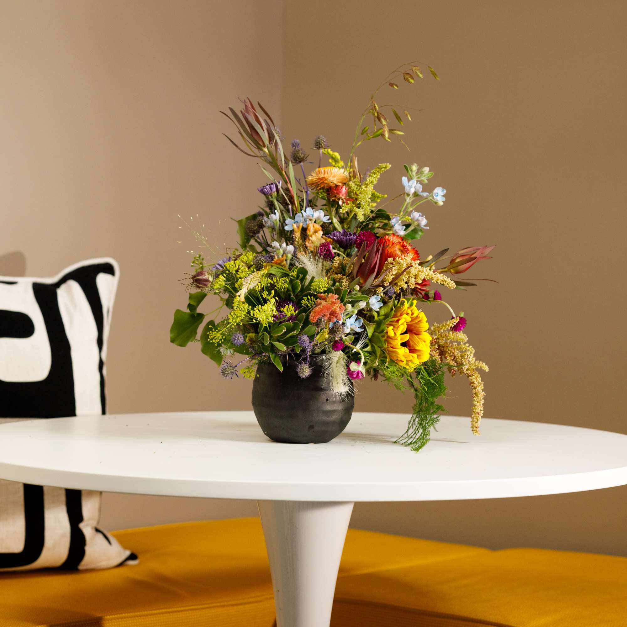 Mixed bouquet in a dark vase on a white table