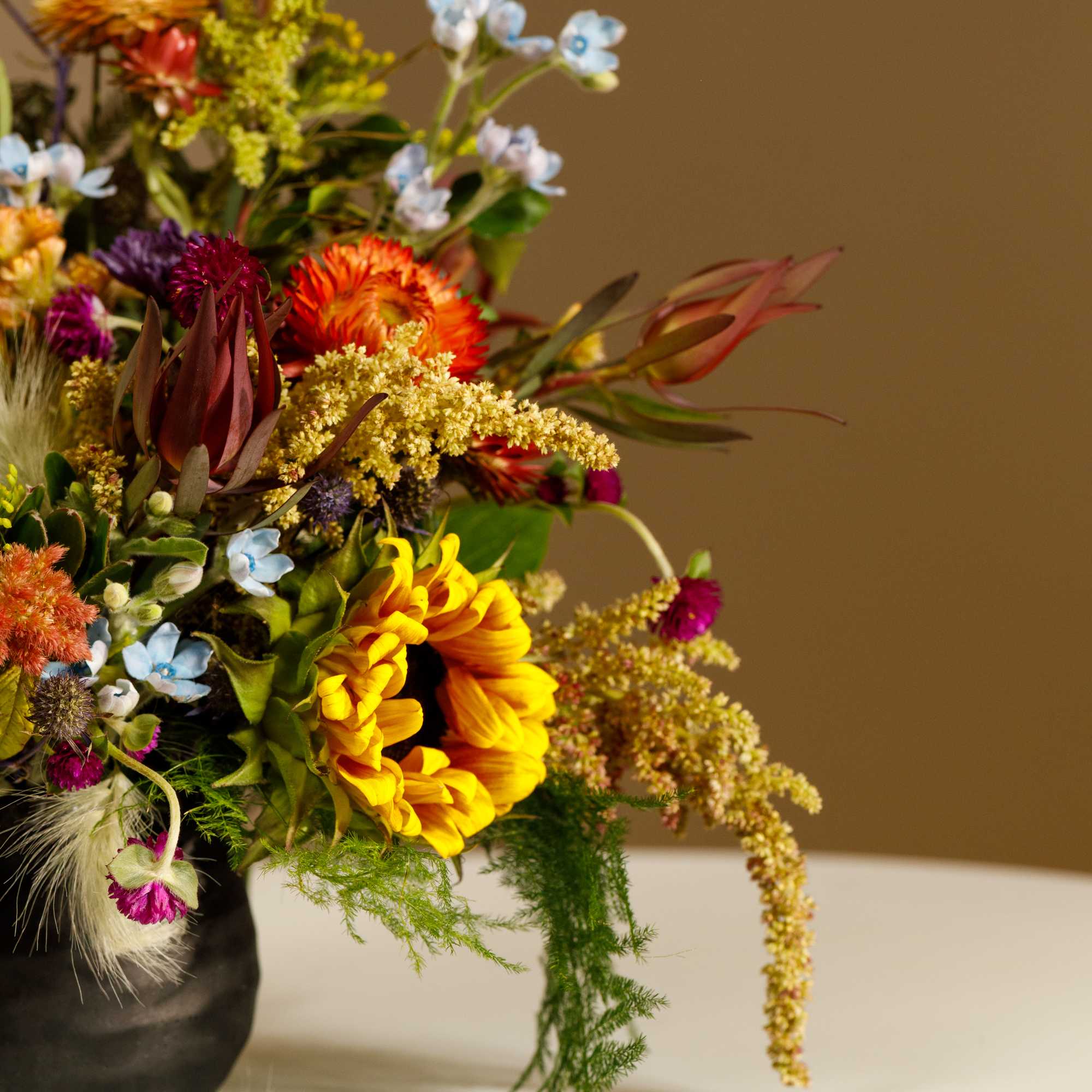 Colorful mixed flower arrangement in a black vase
