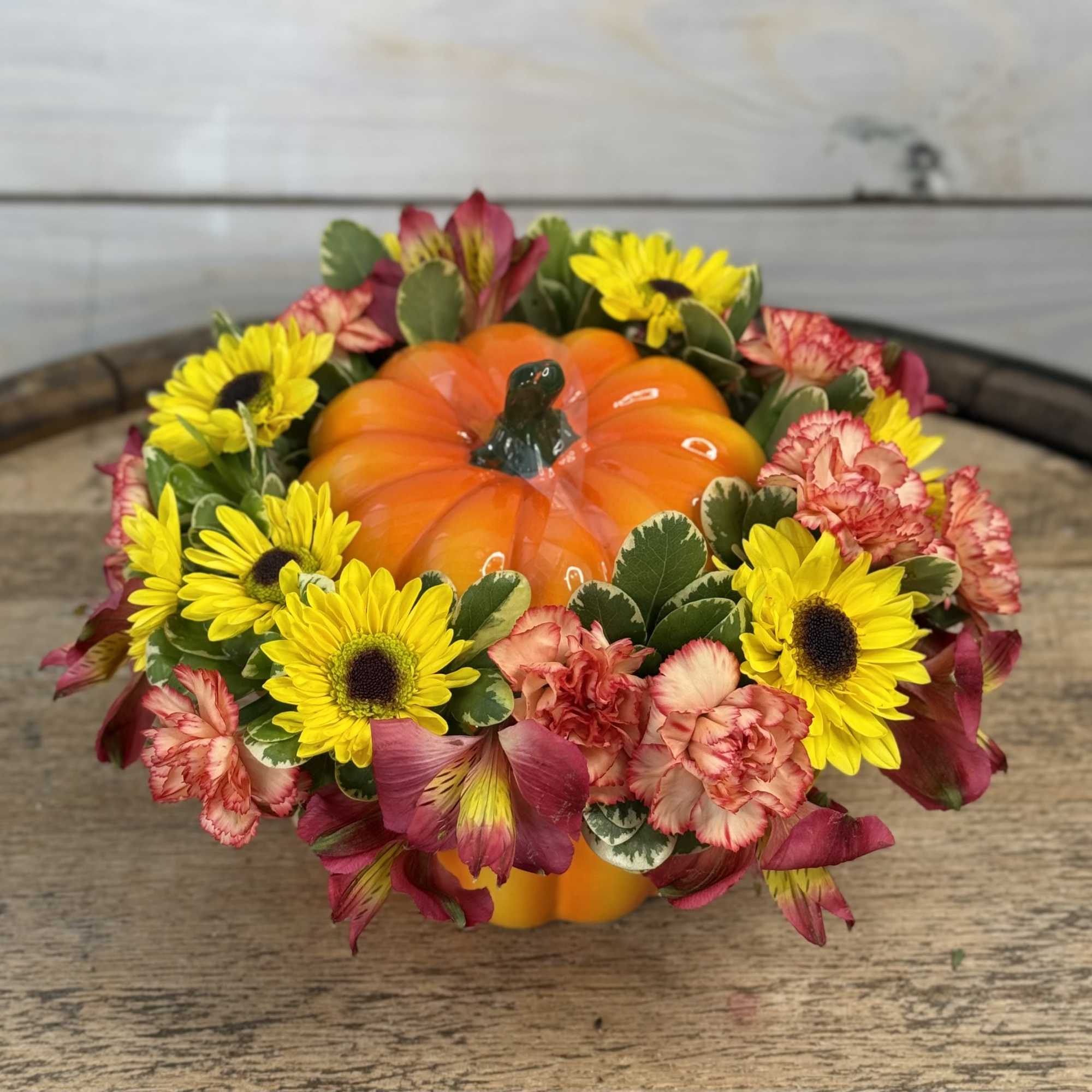 Pumpkin-shaped centerpiece with yellow daisies and pink carnations