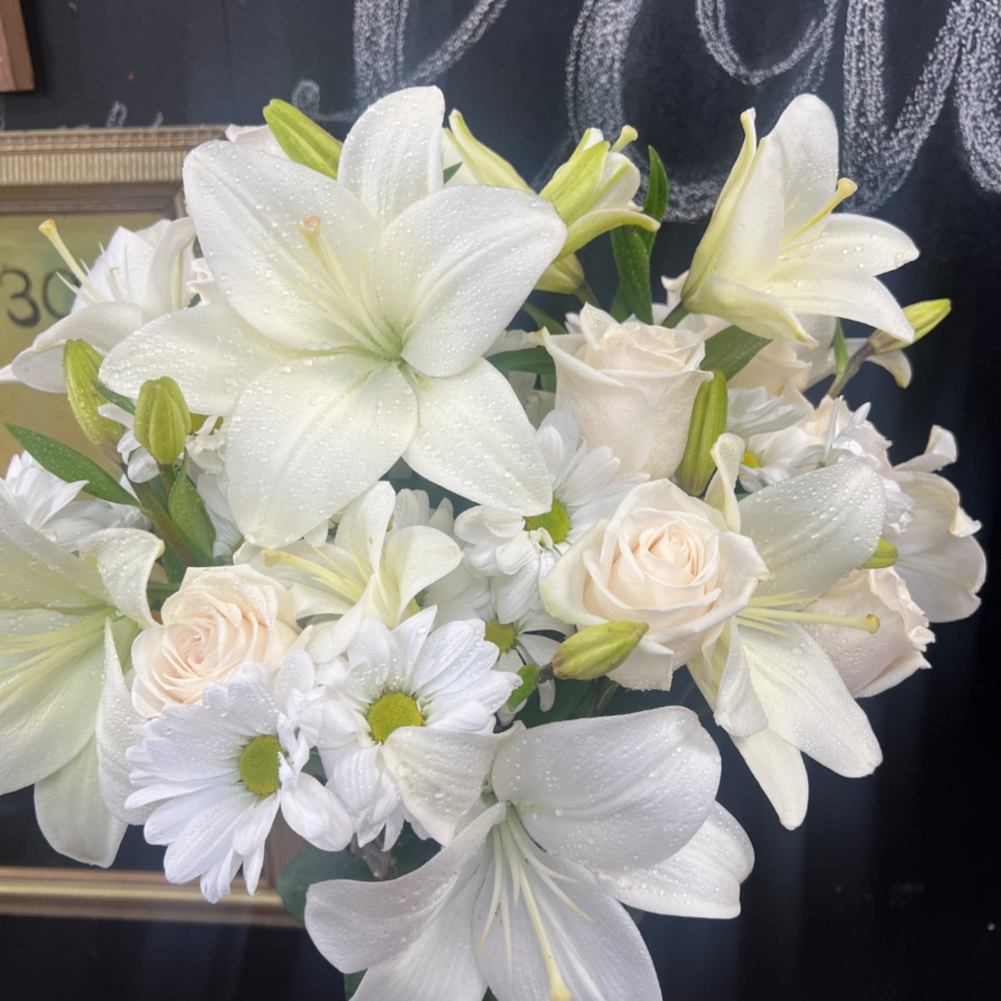 White lilies, roses, and daisies arranged in a bouquet