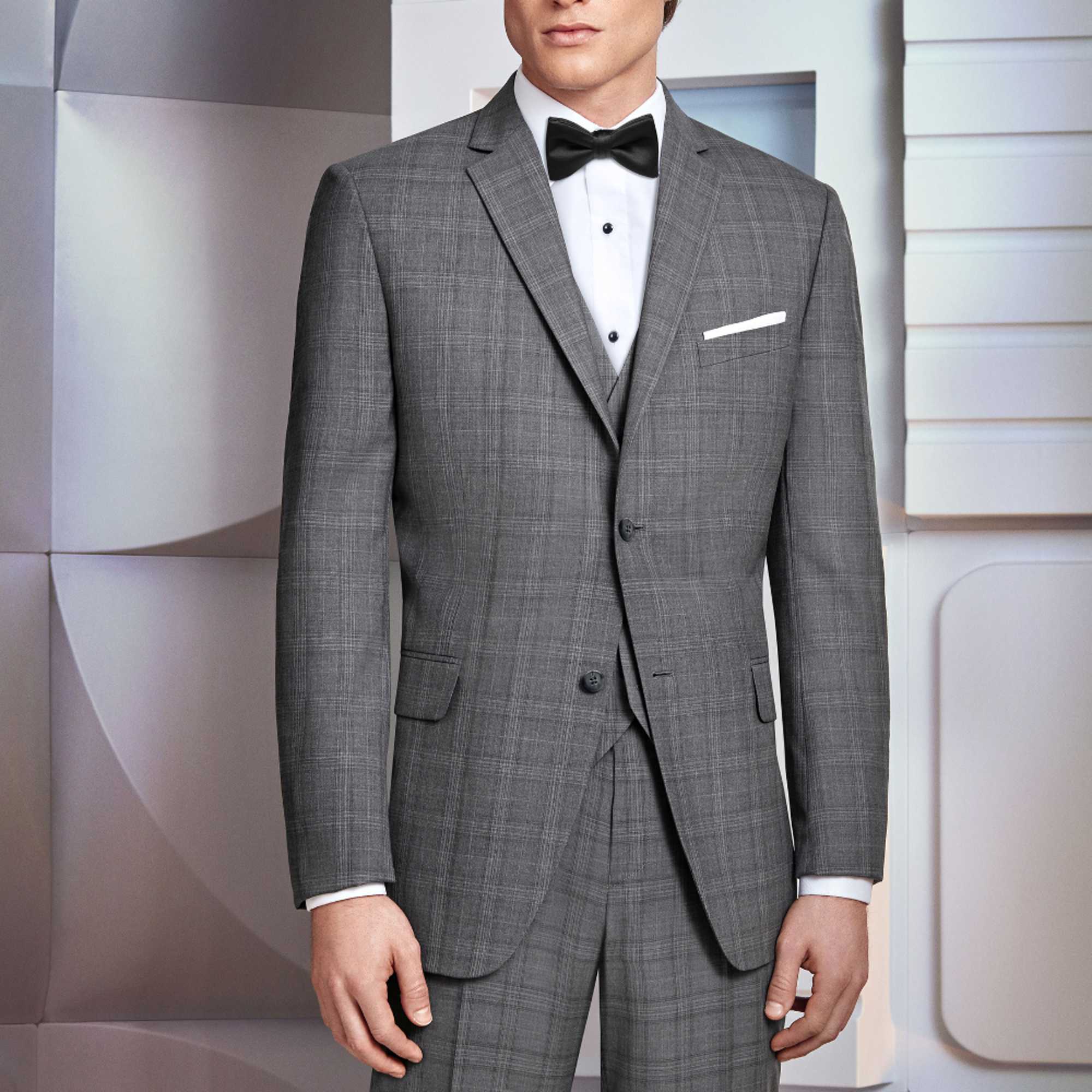 Man wearing a gray suit with a black bow tie