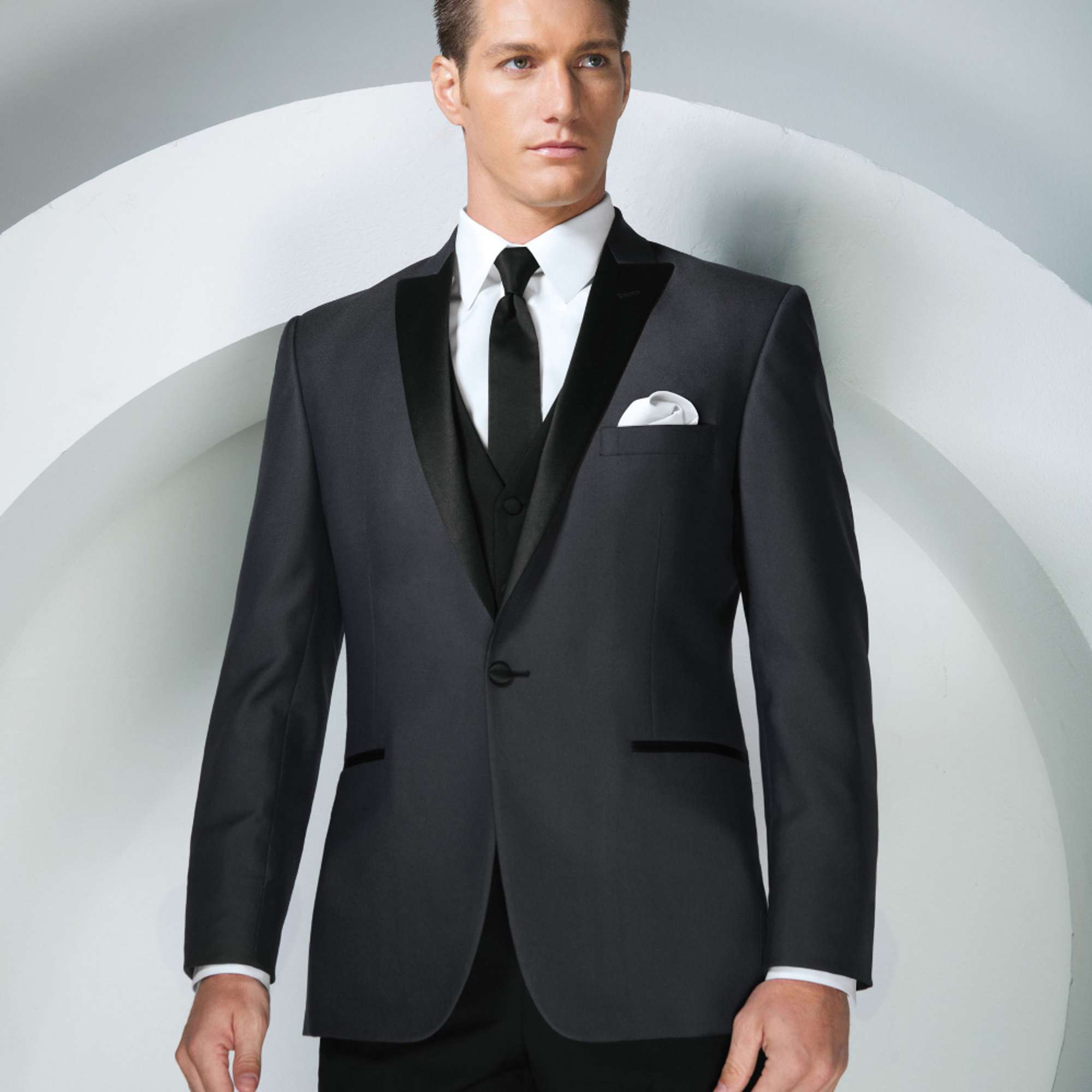 Man wearing a black tuxedo with a white shirt and black tie