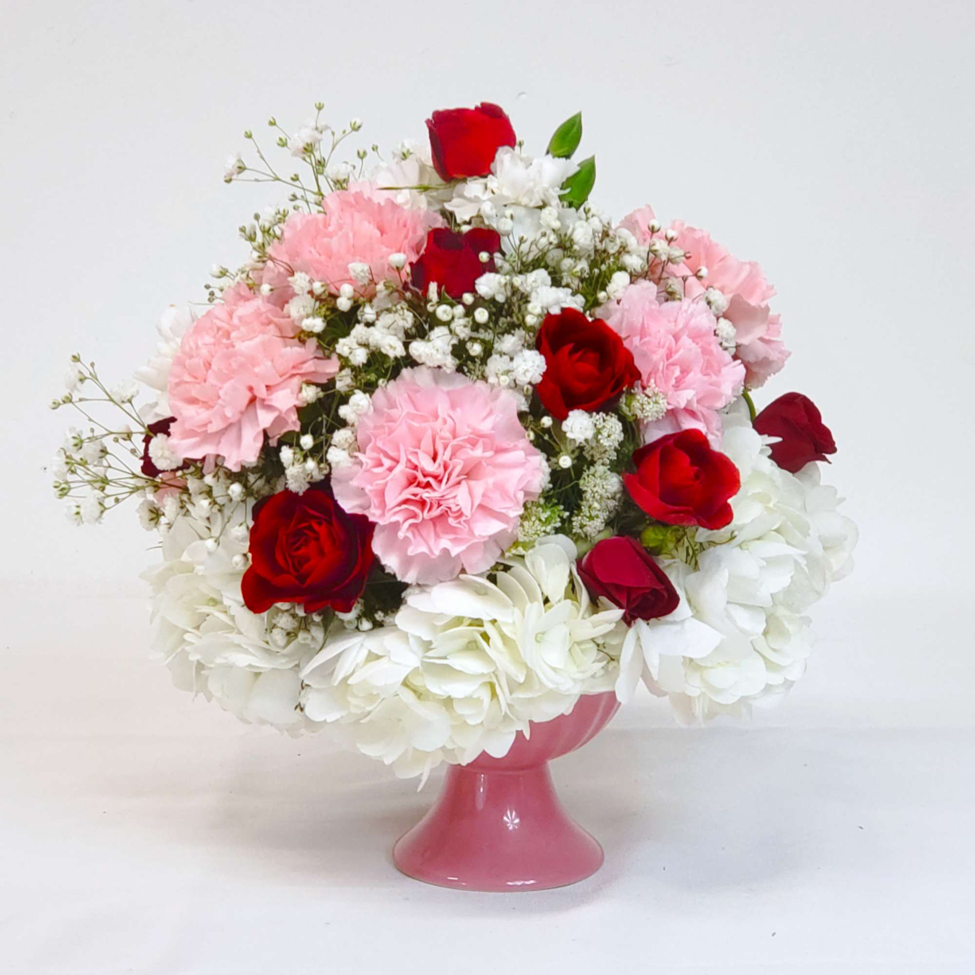 Pink and red flower arrangement in a pink vase