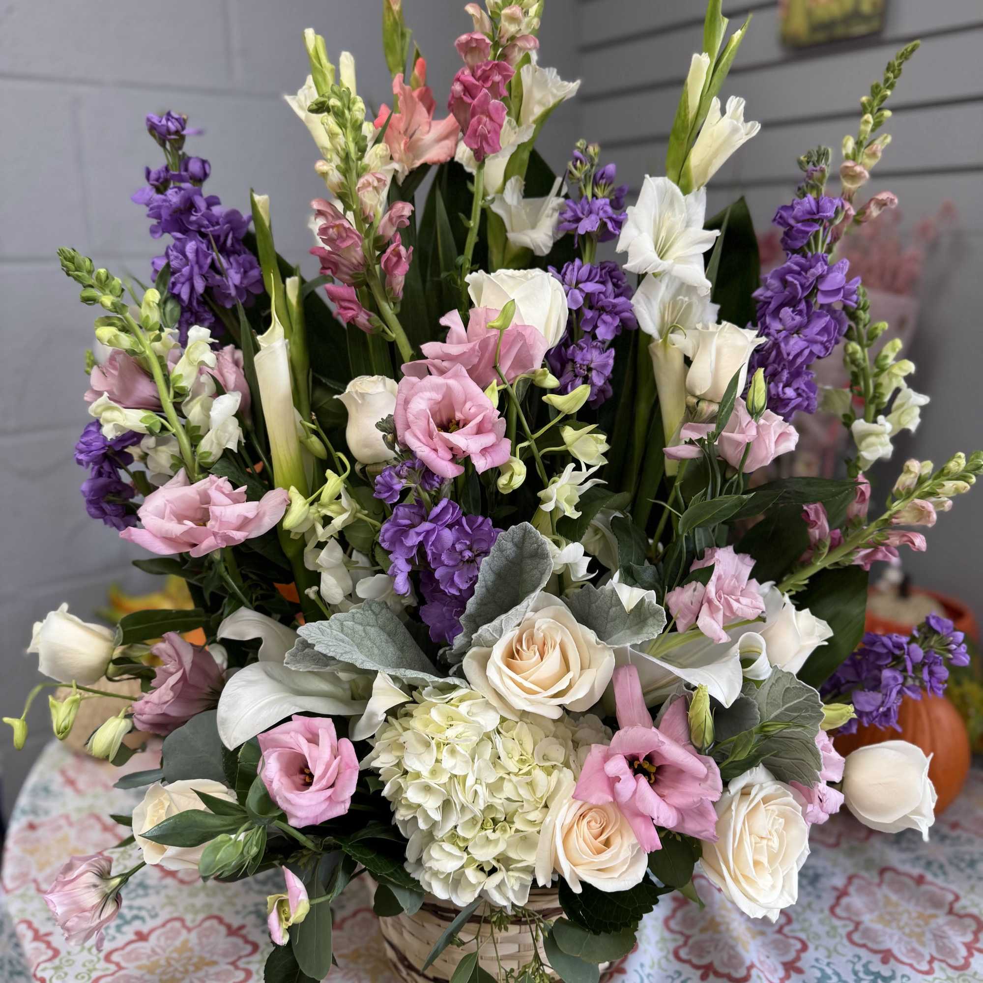 A purple, pink and white fragrant arrangement featuring snapdragons, roses, lilies, and